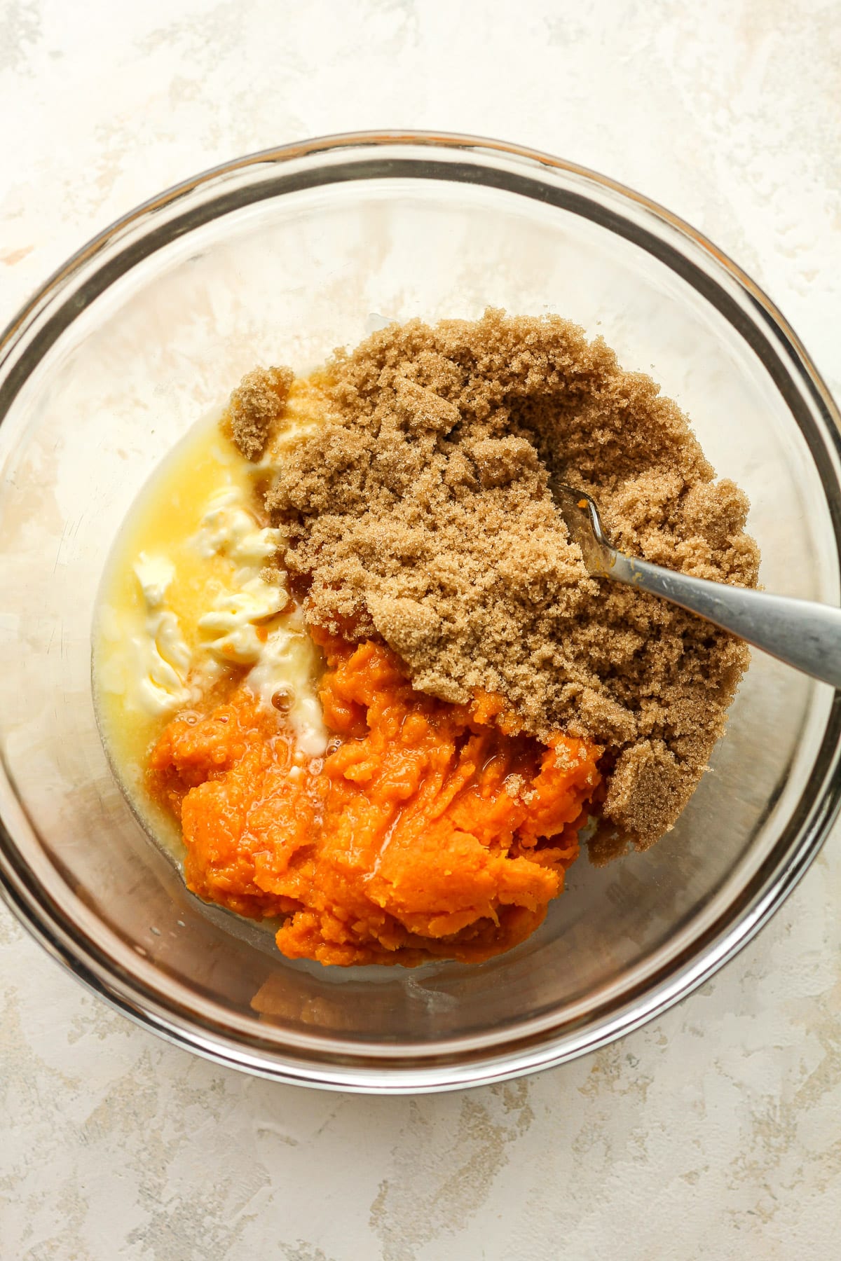 A bowl of the melted butter, mashed sweet potato, and brown sugar.
