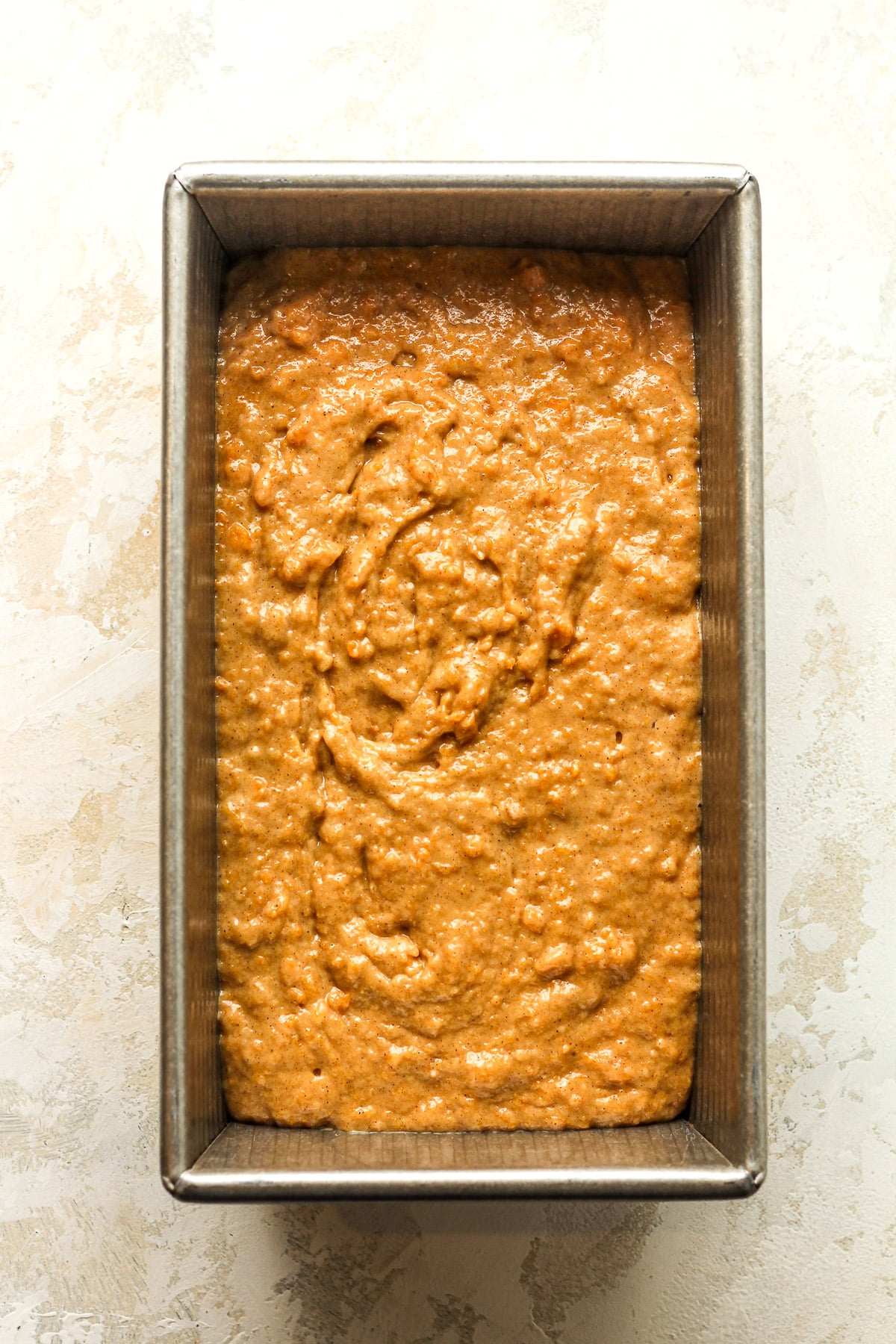 A loaf pan of the raw sweet potato bread dough.