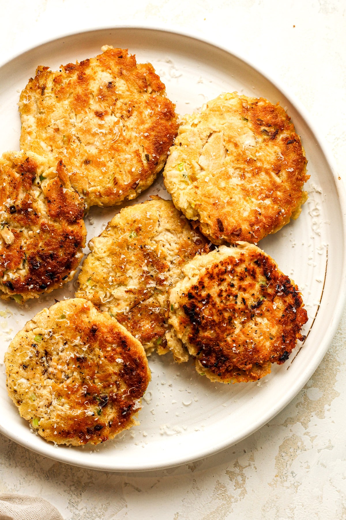 A plate of just browned tuna patties with green onion.