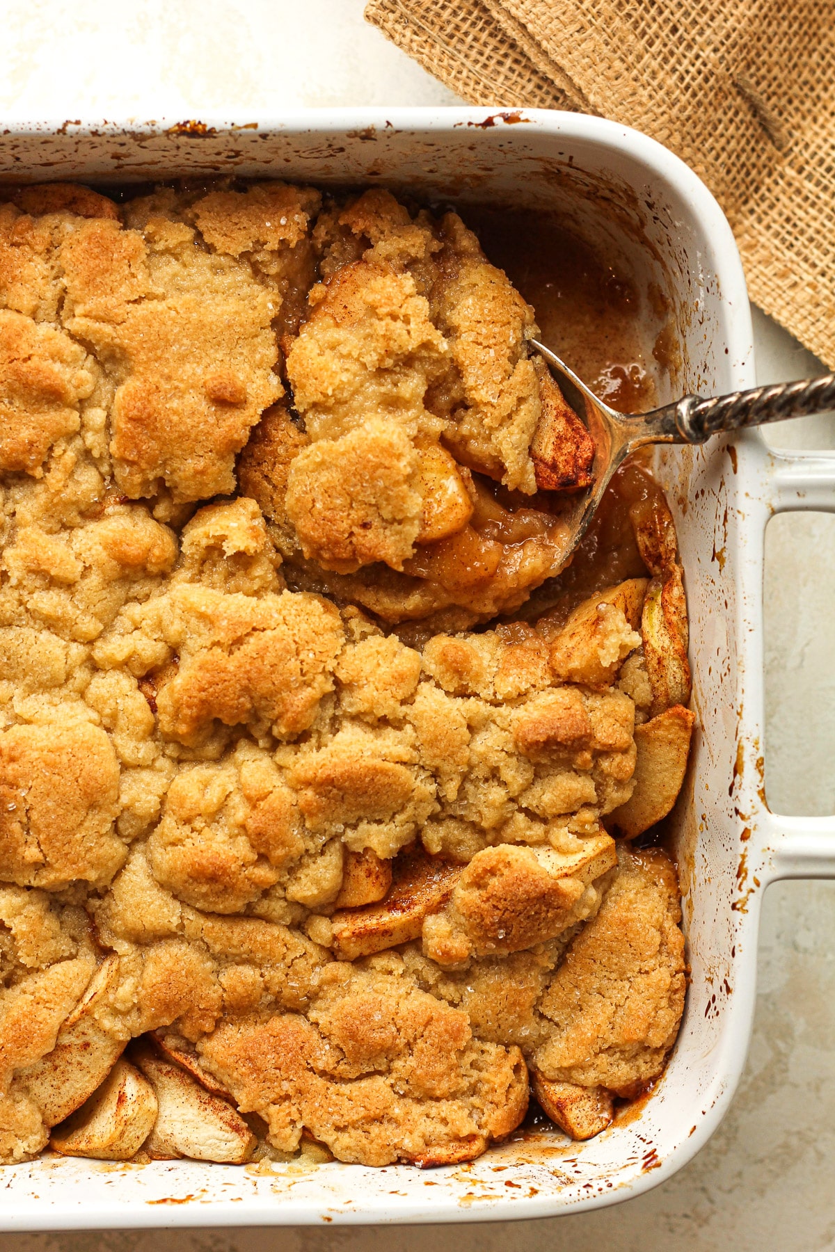 Closeup of a dish of cobbler with a serving spoon digging in.