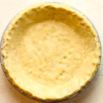 An all butter pie crust rolled out into a pie plate.