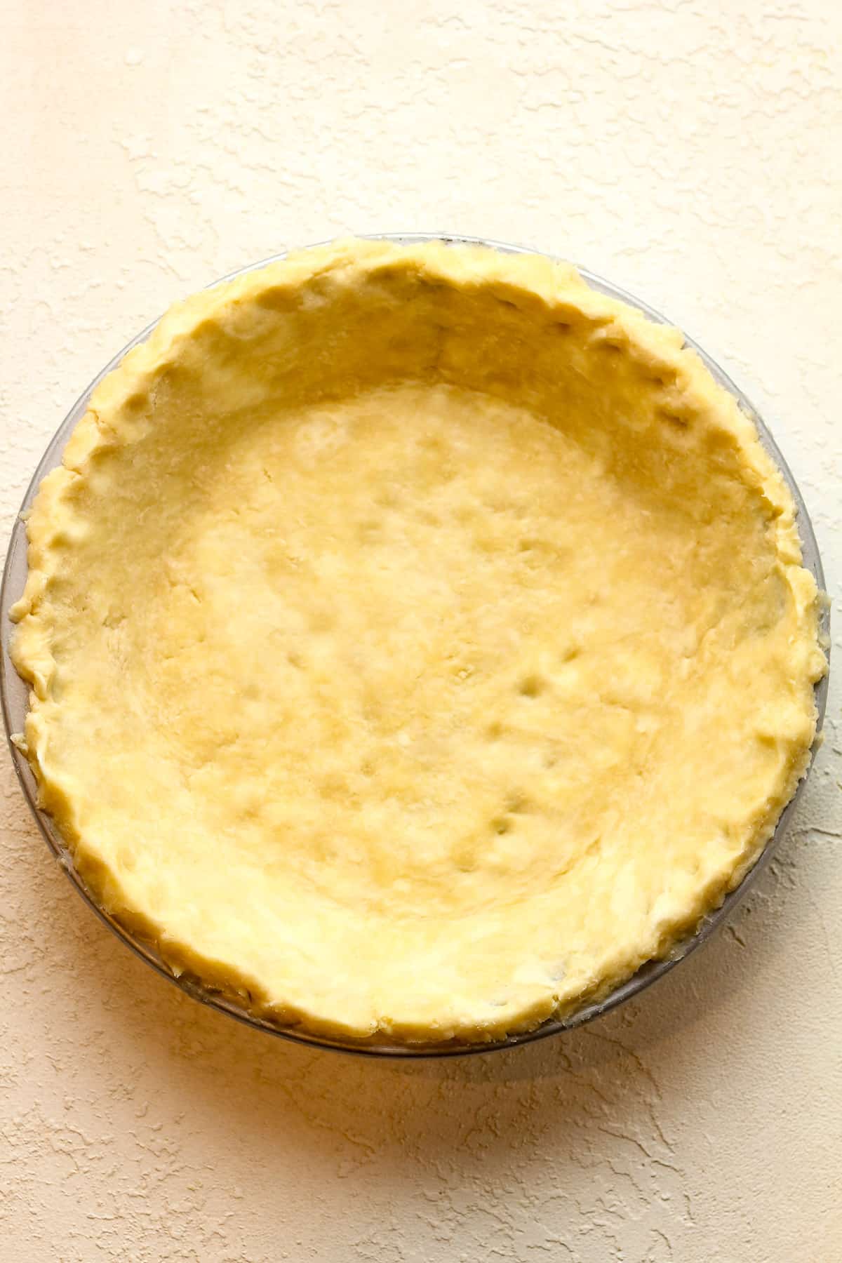 The pie dough pressed into a pie plate.