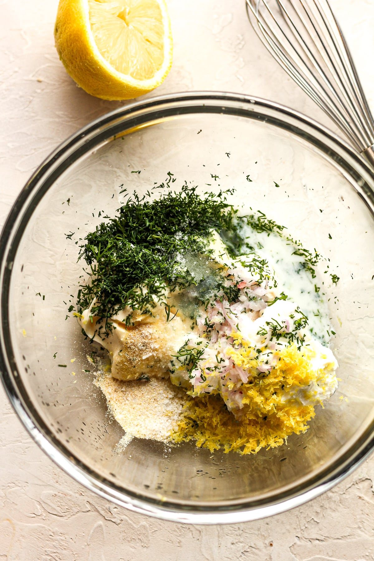 A bowl of the lemon dill sauce ingredients before combining.