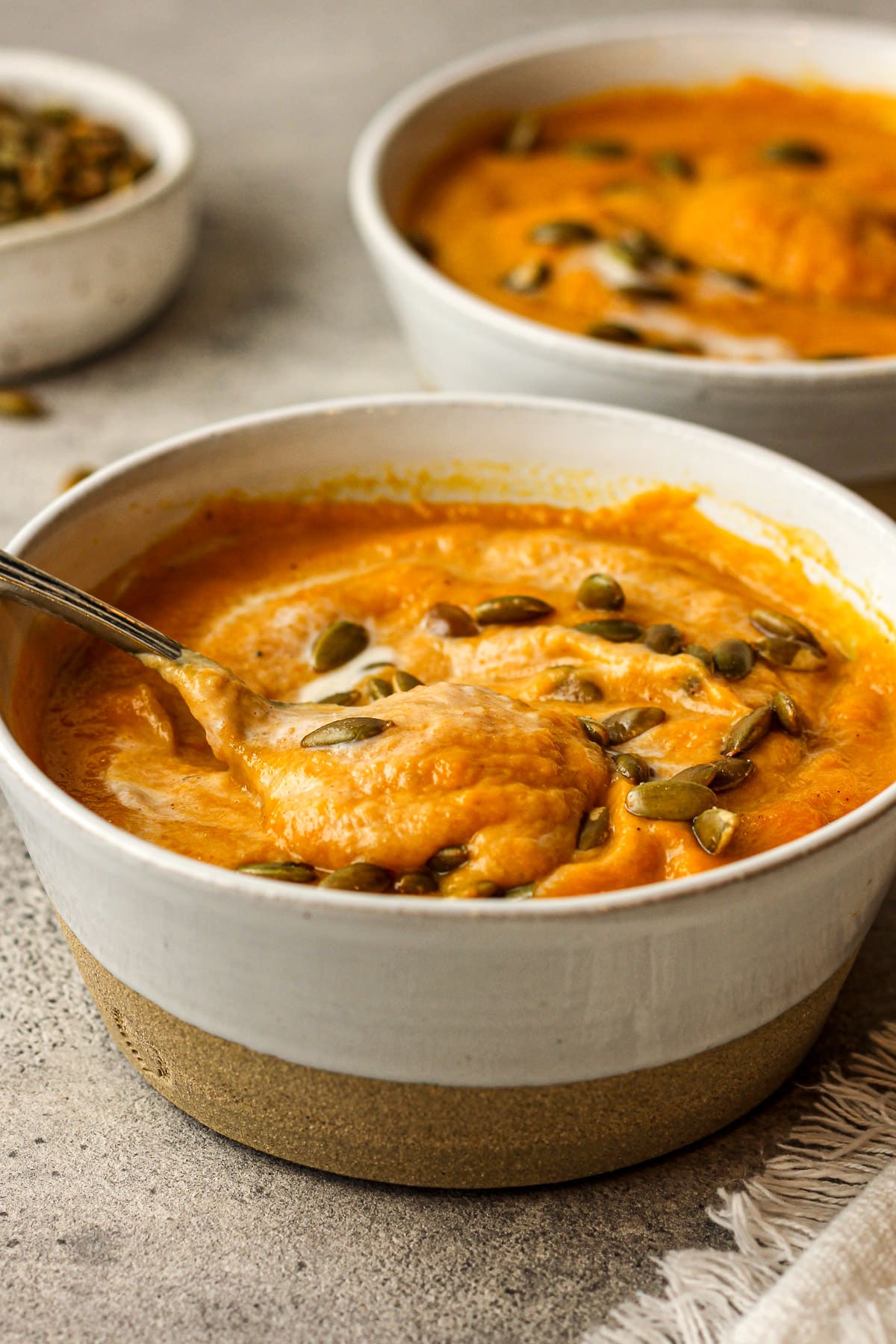 Side view of two bowls of Panera copycat Autumn squash soup.