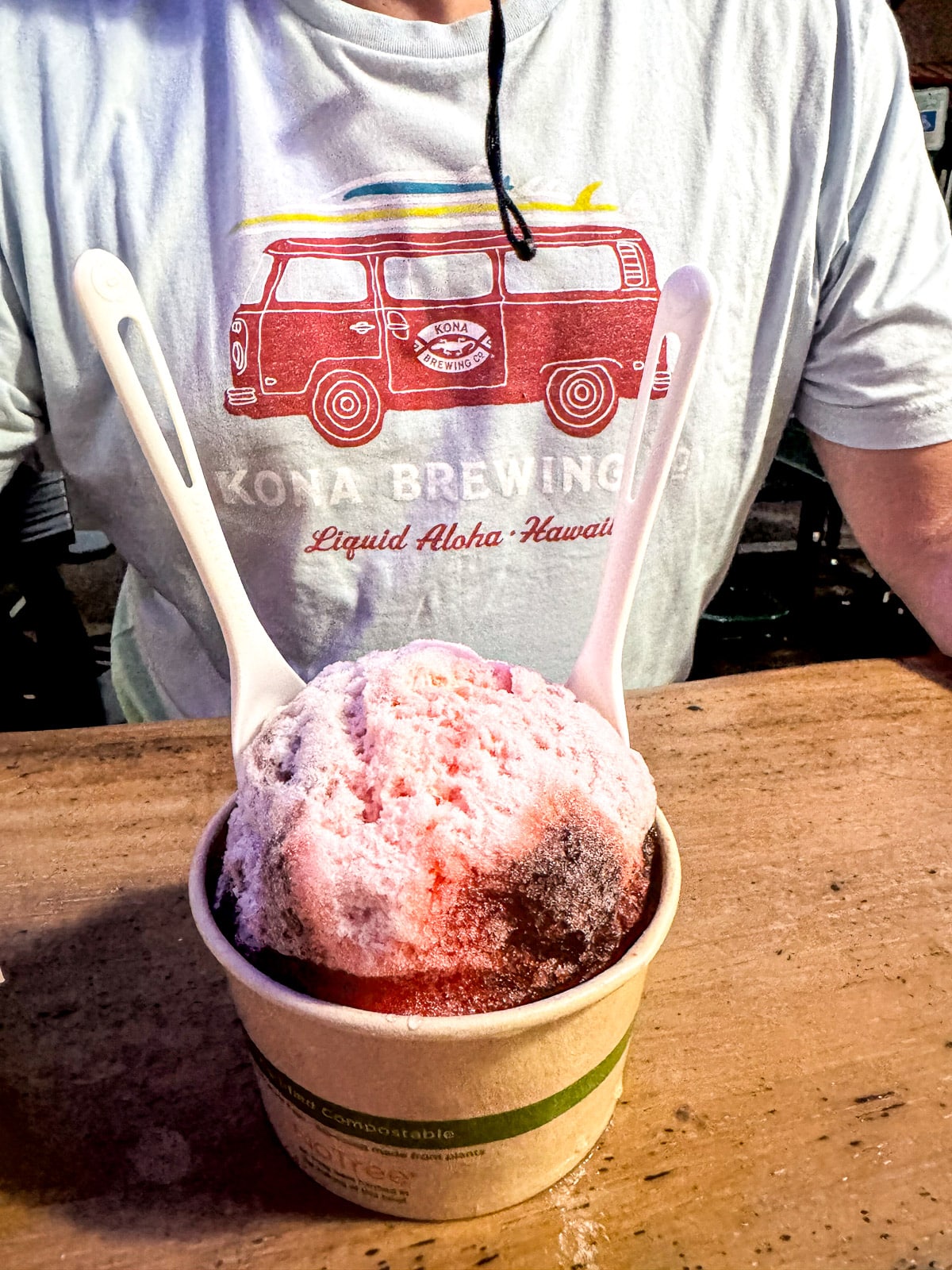 A cup of shaved ice in front of Mike's shirt.