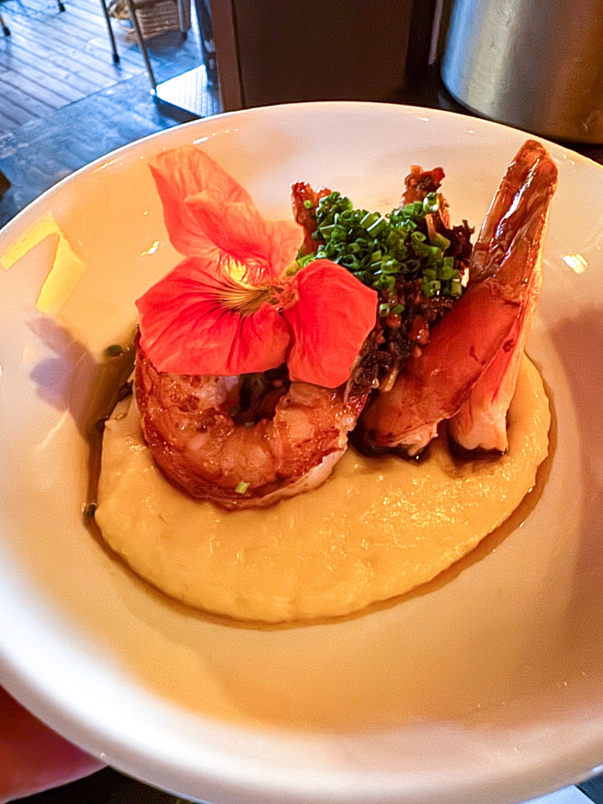 A bowl of spicy shrimp over pureed potatoes.