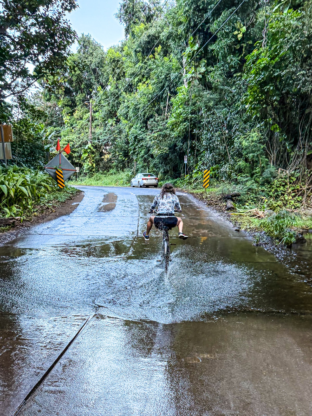 Me biking over a flooded part of the road near Tunnels Beach.