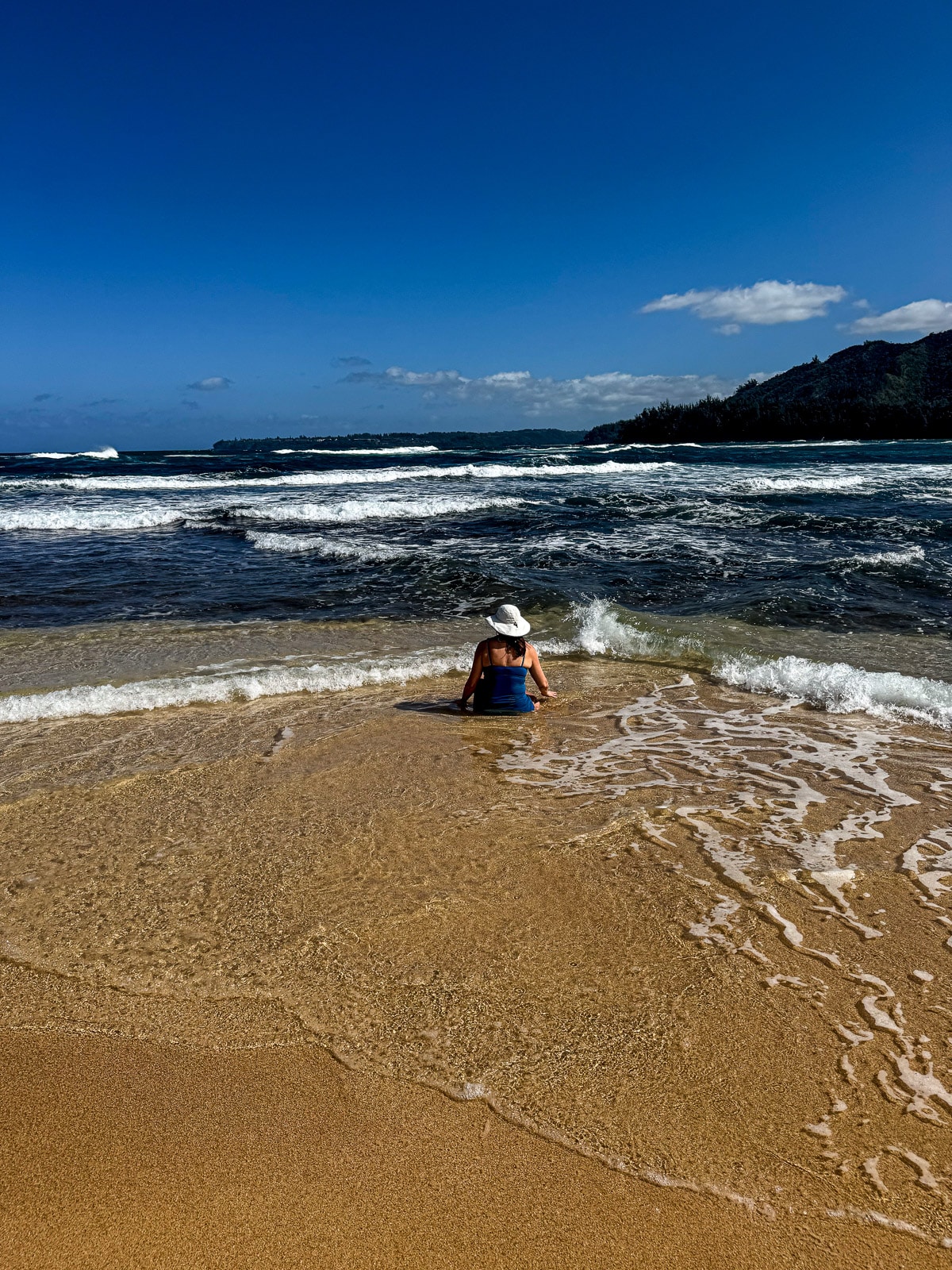 Me sitting in the sand in the shallow part of the ocean.