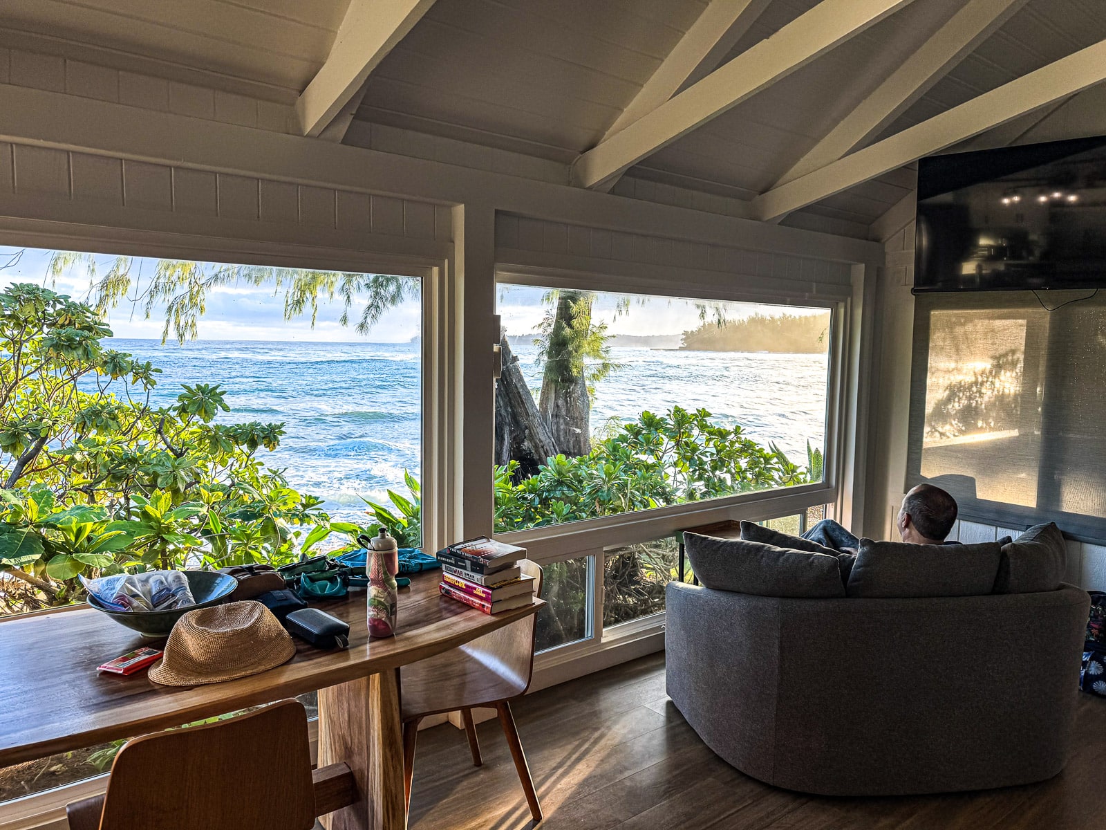 Mike on a chair by a window in front of the ocean.