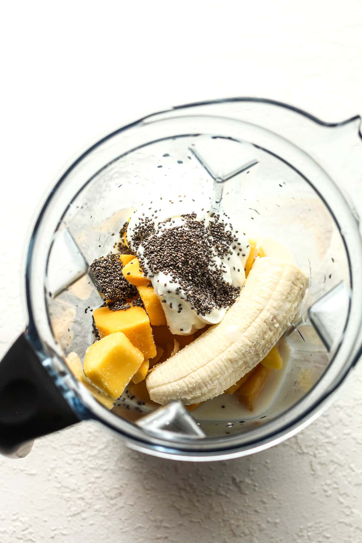 A blender of the mango smoothie ingredients.