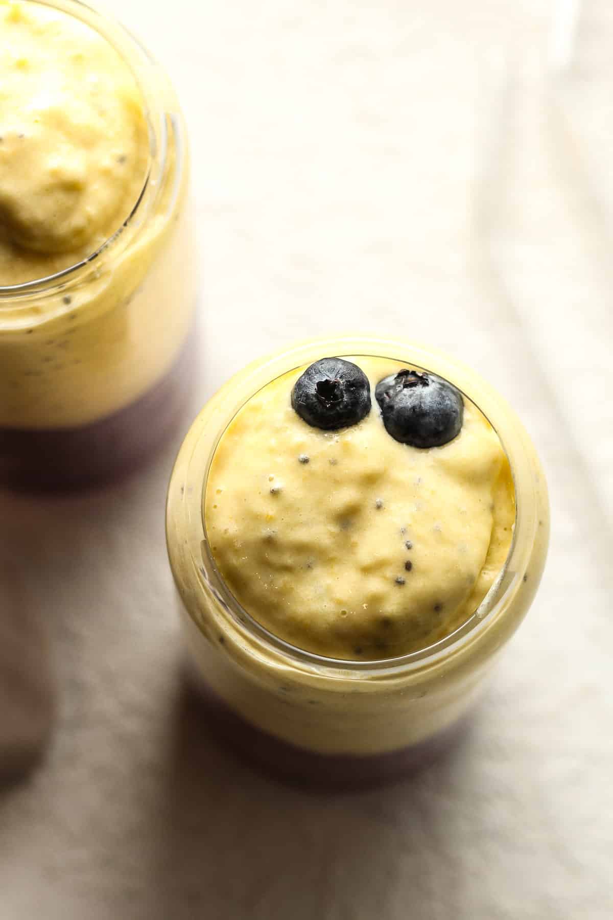 Overhead view of two fruit smoothies with straws.