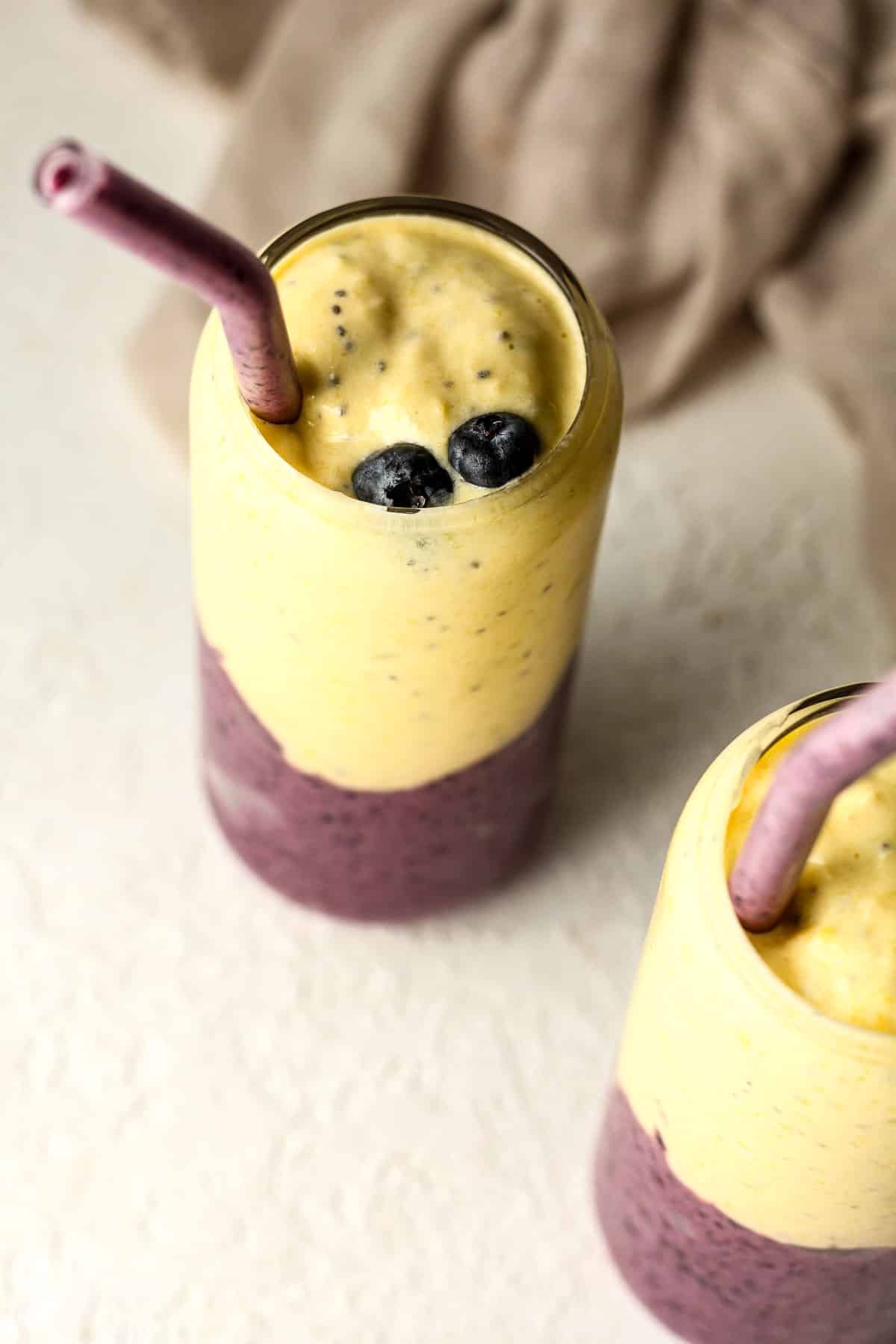 Overhead view of two frozen fruit smoothies layered in glasses.