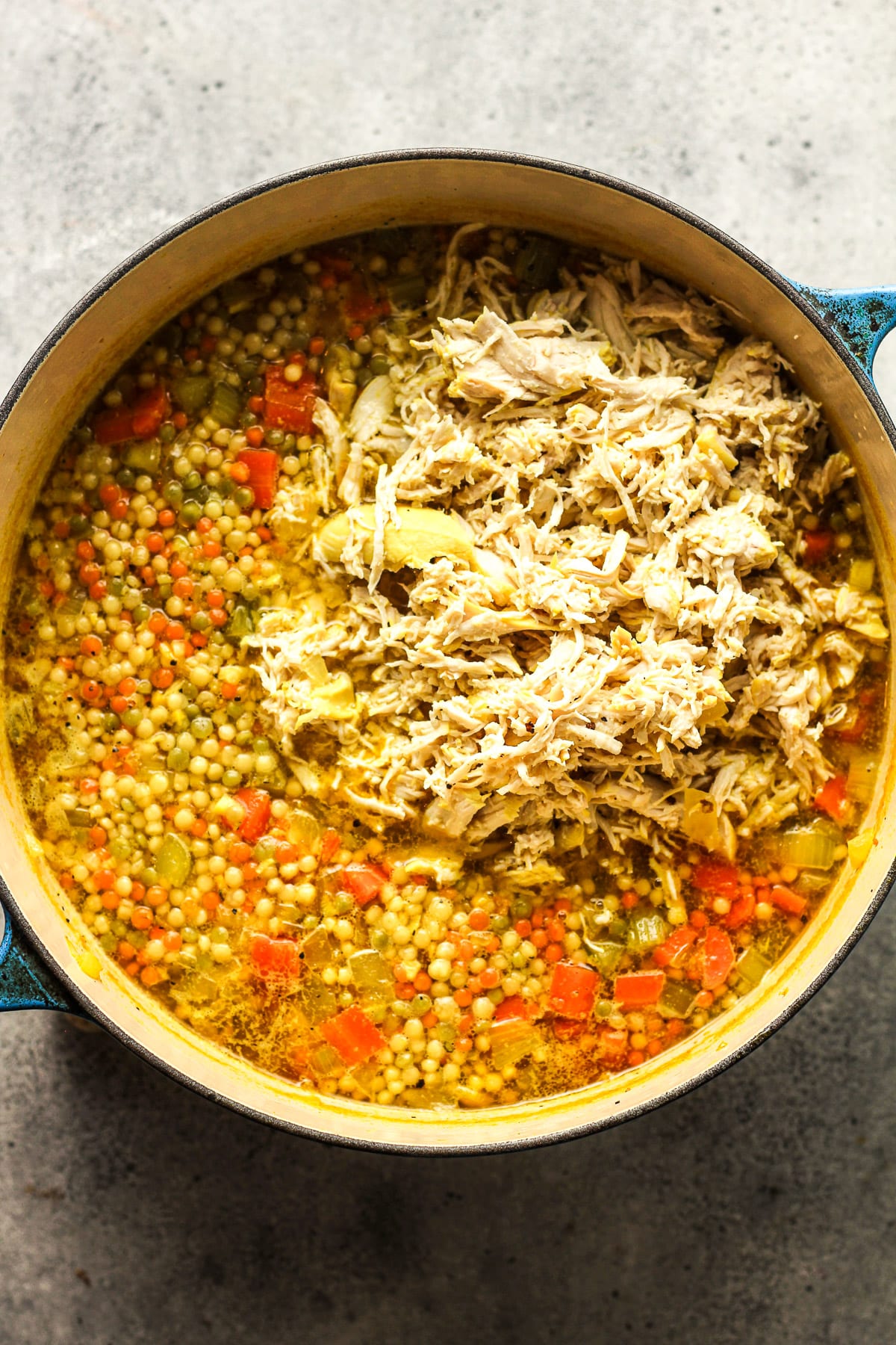 A pot of the soup after adding the shredded chicken.