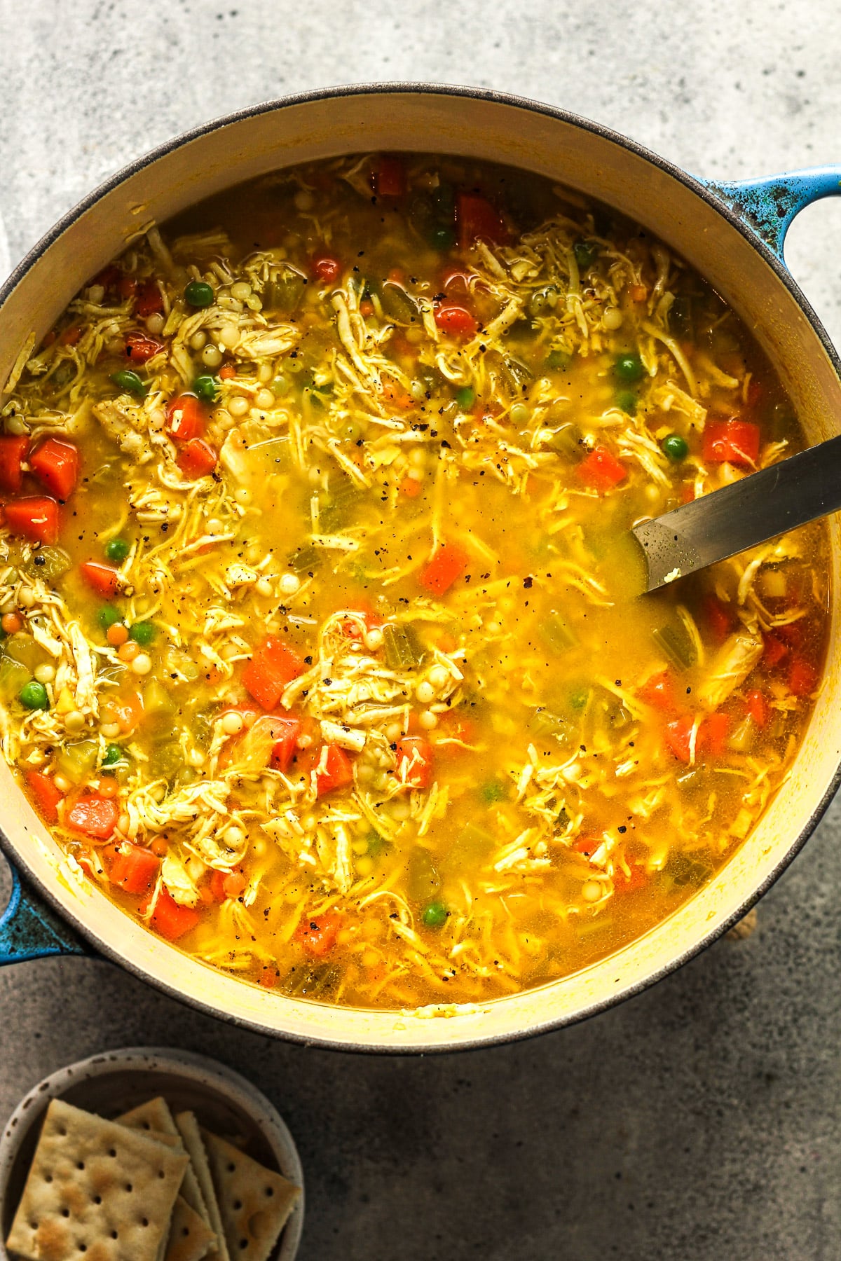Overhead view of a stockpot of chicken and couscous soup.
