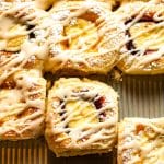 A closeup on a pan of cream cheese kolaches with some of them pulled apart.