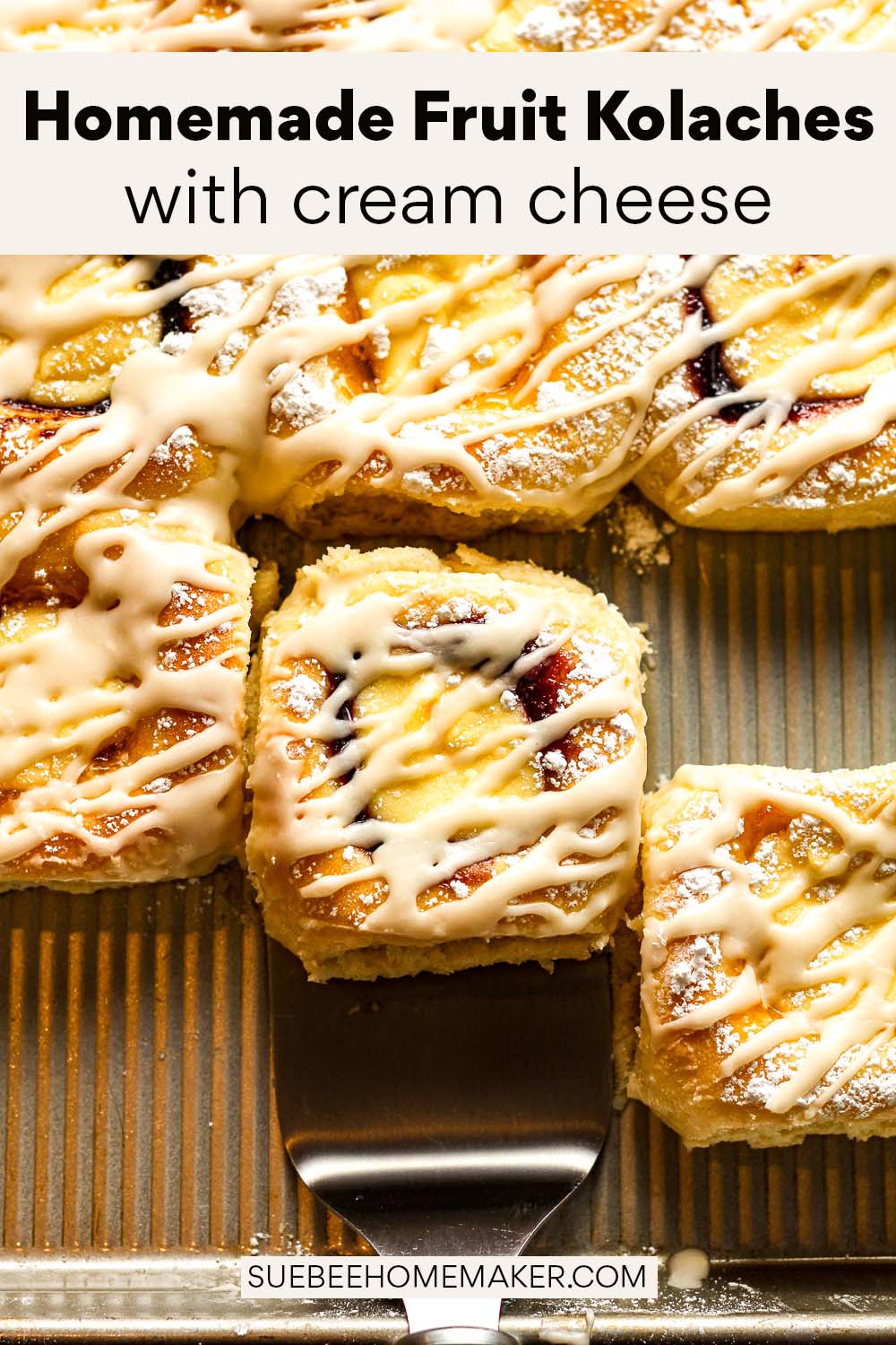 A tray of homemade fruit kolaches with cream cheese showing a spatula pulling one out.