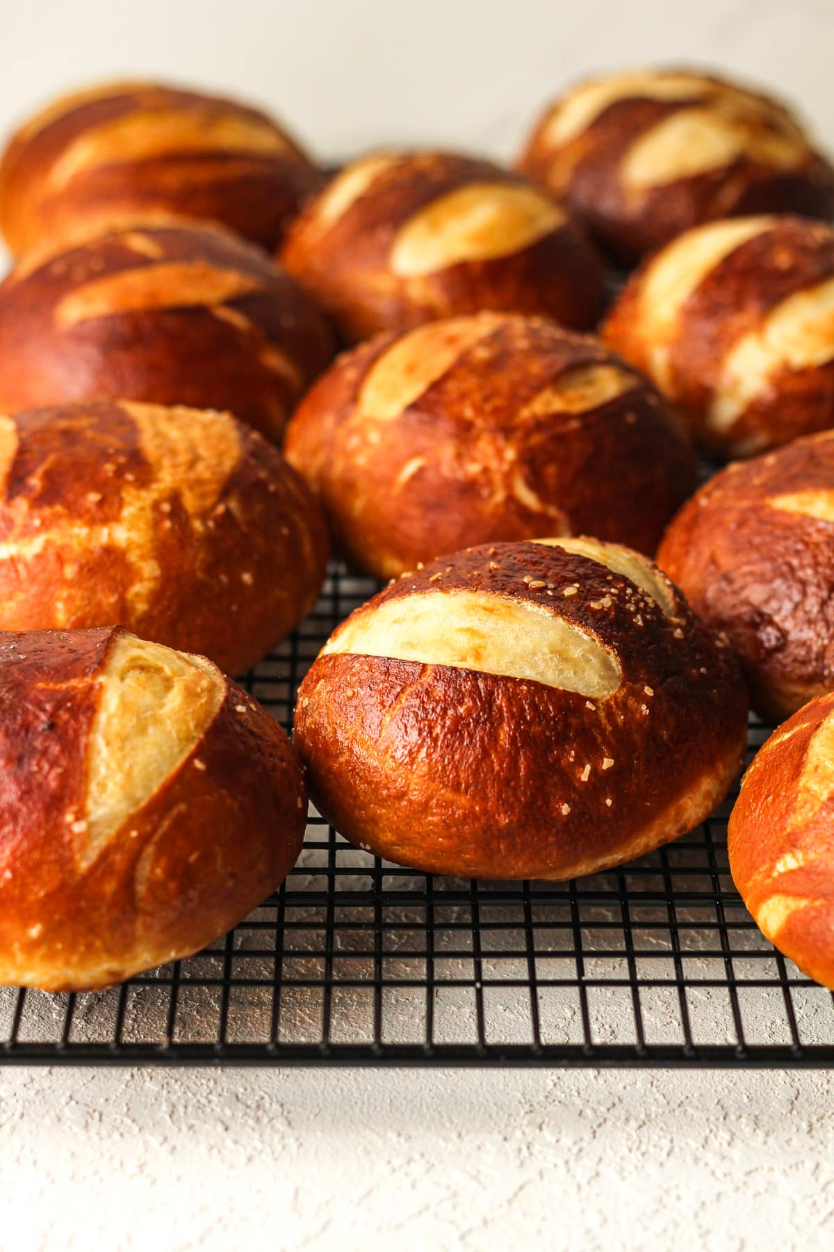 Side view of a wire rack of pretzel buns.