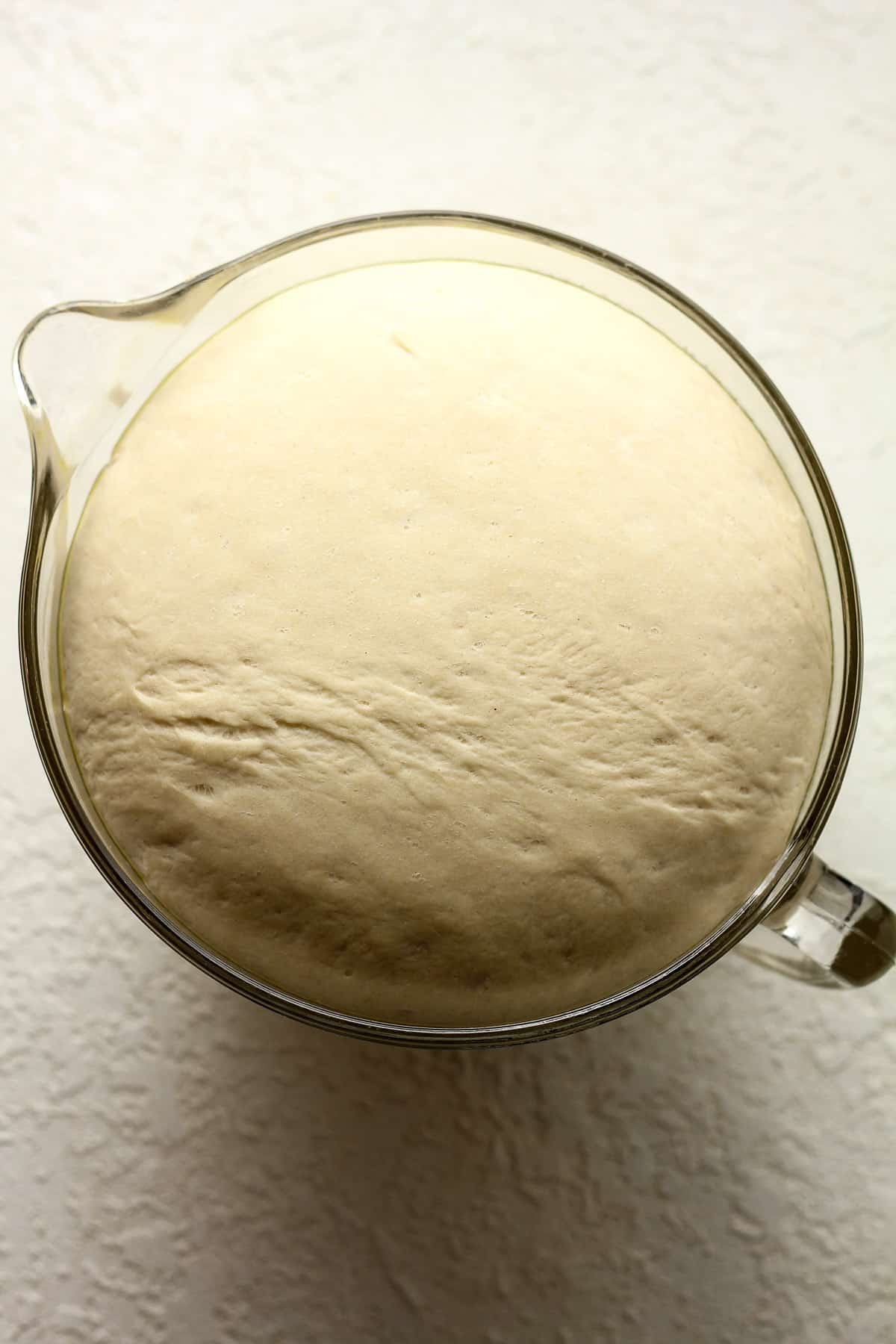 A large 8-cup measuring cup of the pretzel bun dough.