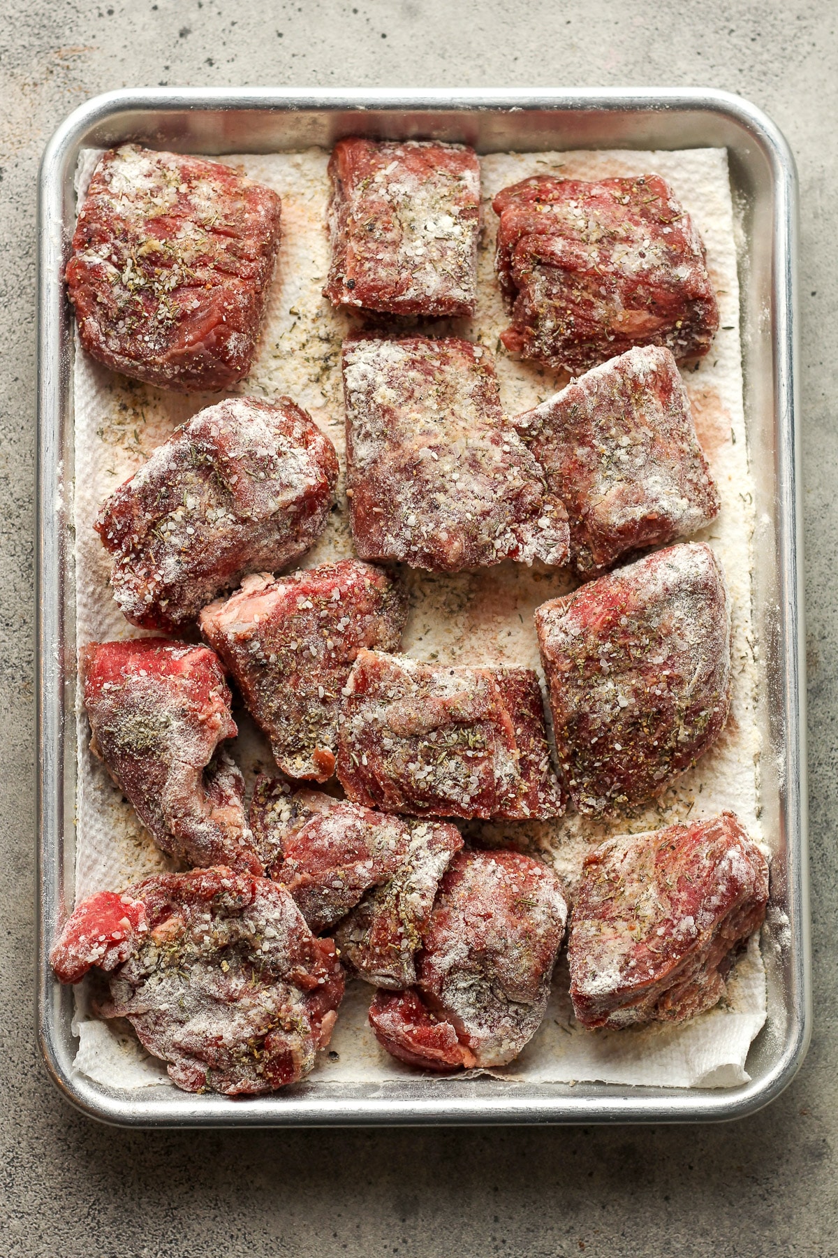 Chunks of the beef with seasoning plus flour.