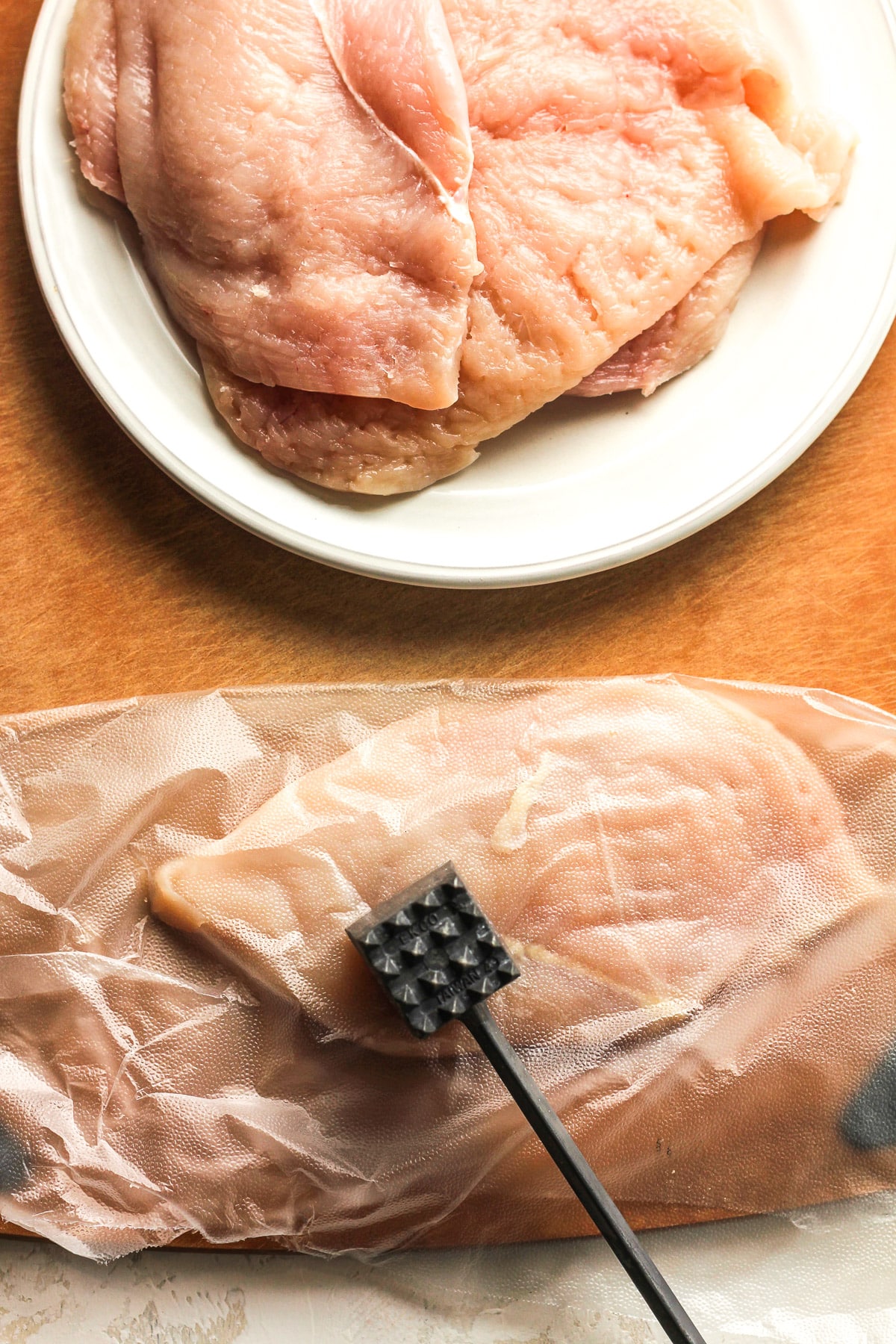 A plate of the cutlets and then one of them being pounded flat.