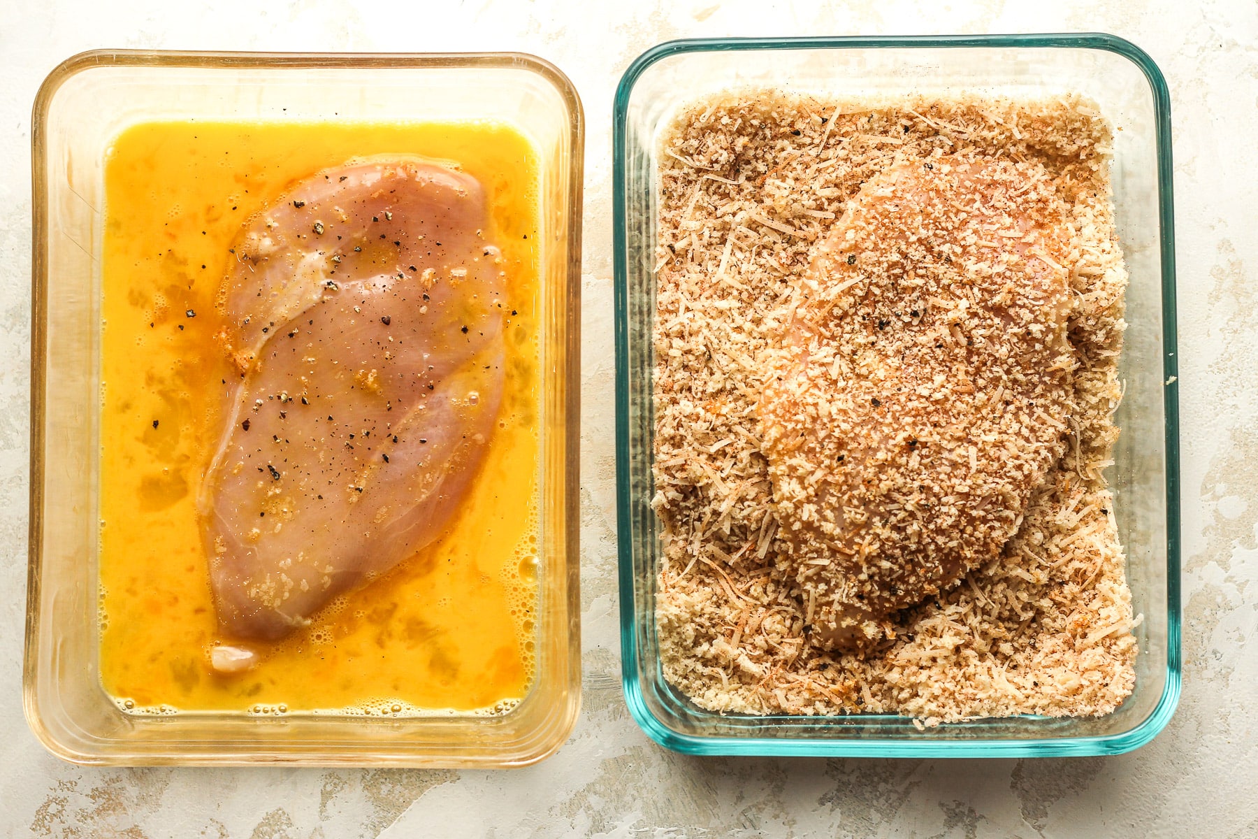 Two dishes - one with a chicken cutlet in whipped eggs and one with a chicken cutlet in the breadcrumb mixture.