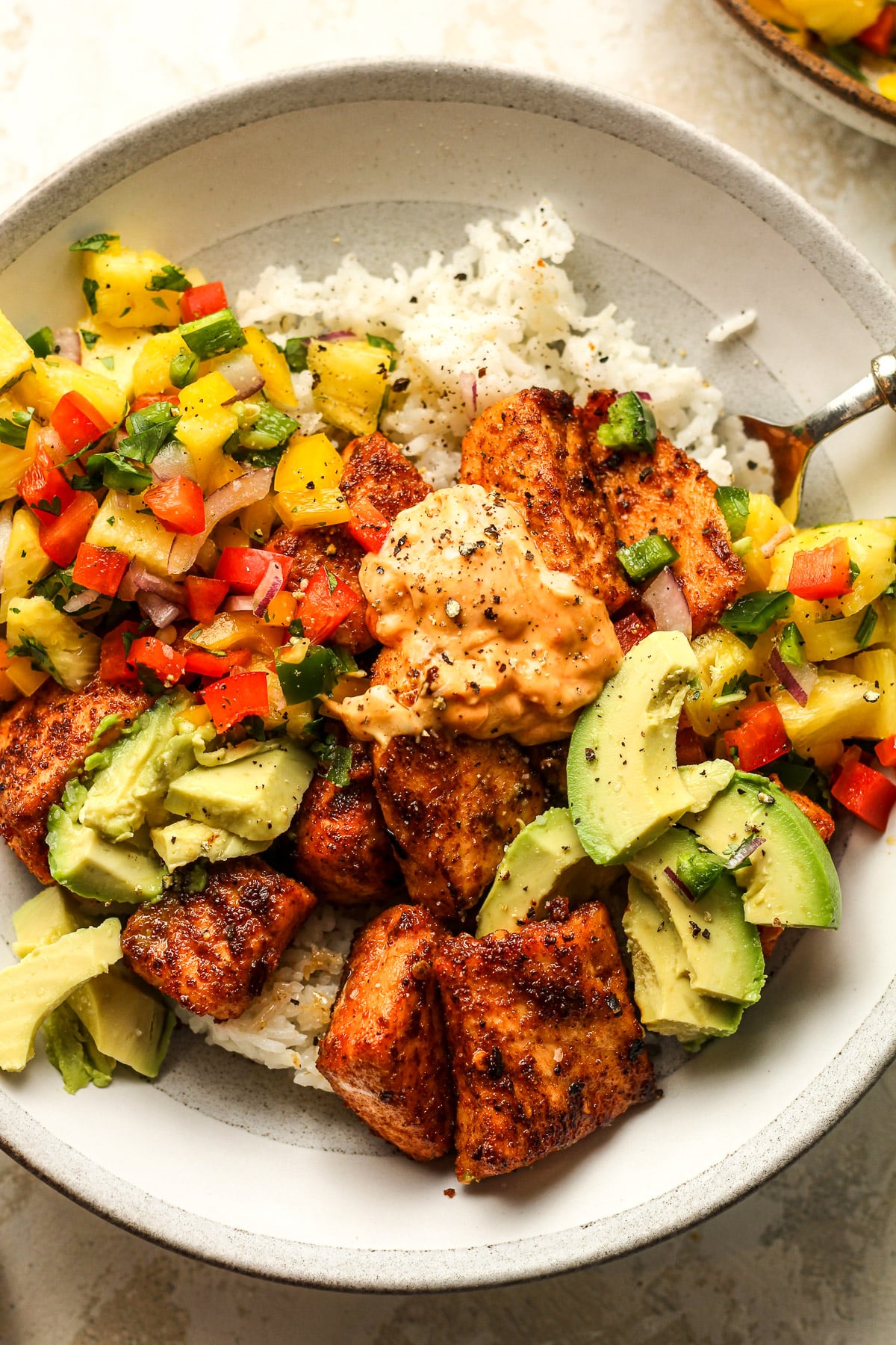A salmon bowl with blackened seasoning and salsa.
