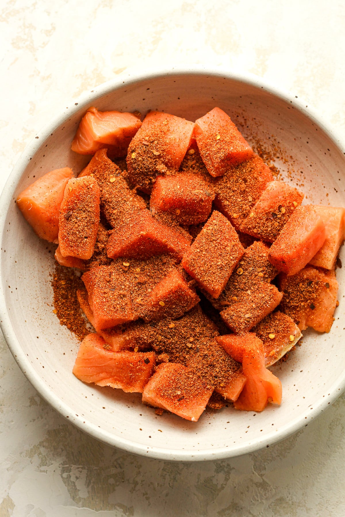 A bowl of the salmon bites with blackened seasoning on top.