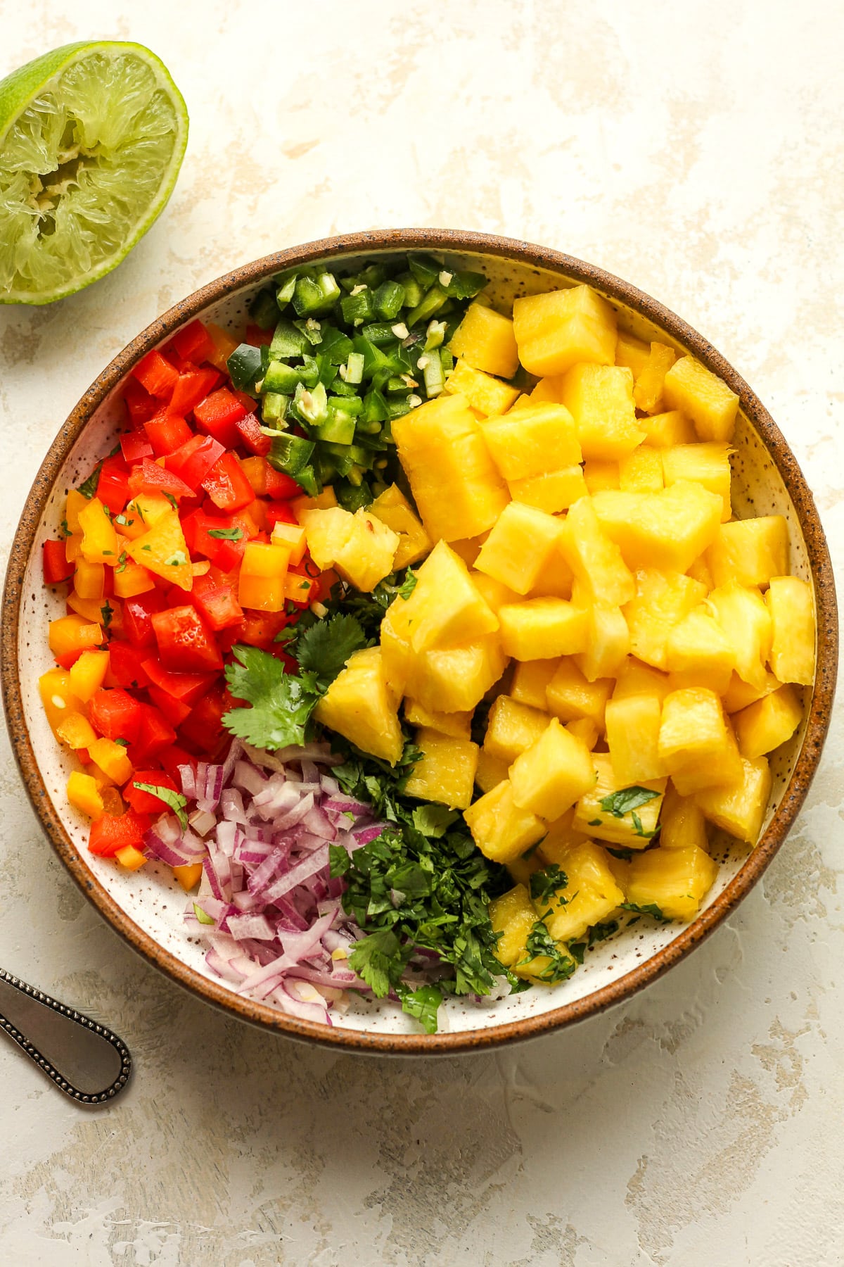 A bowl of the pineapple salsa with ingredients separated.
