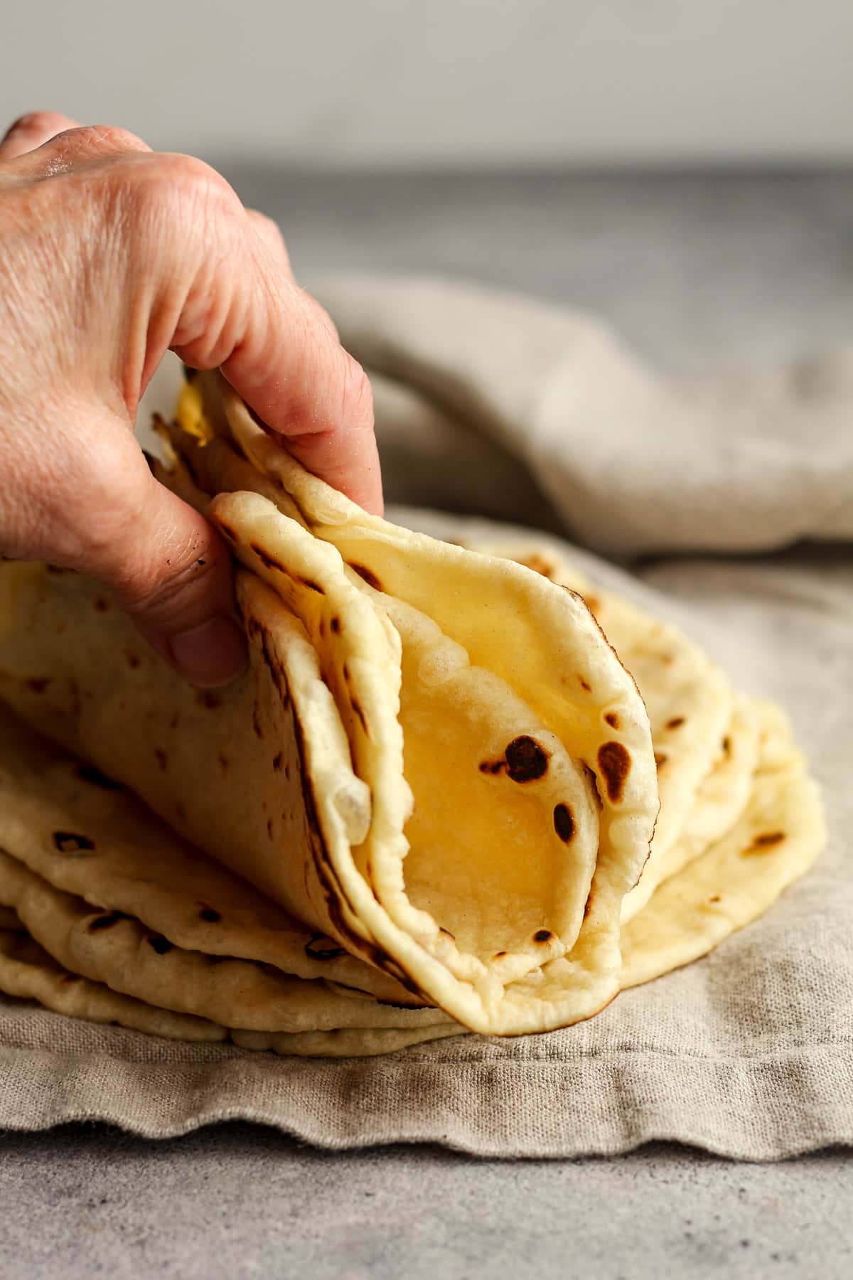 My hand holding two folded tortillas.