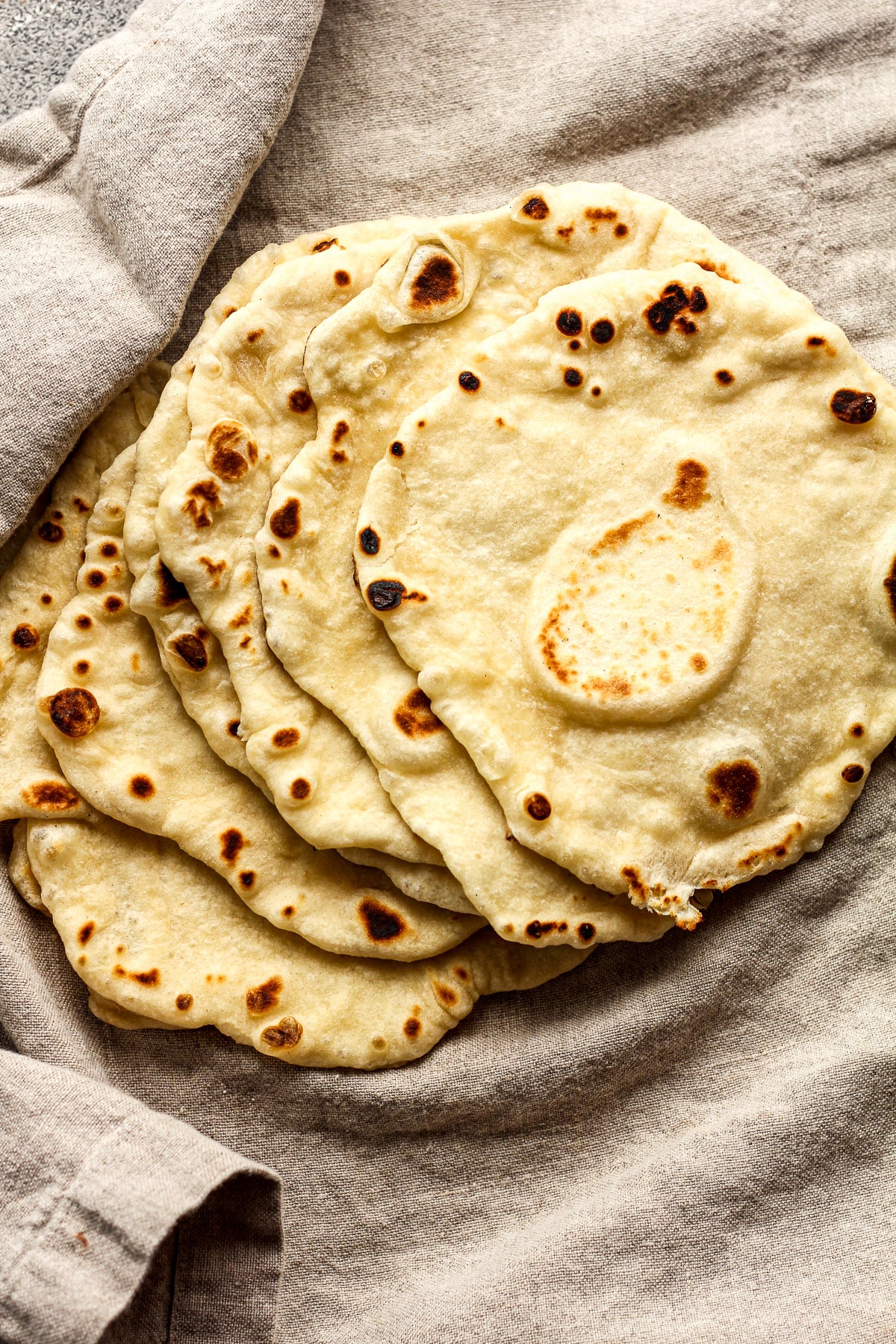 Some flour tortillas on a gray napkin.