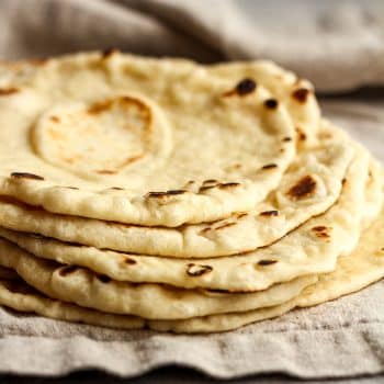 Side view of some stacked homemade flour tortillas.