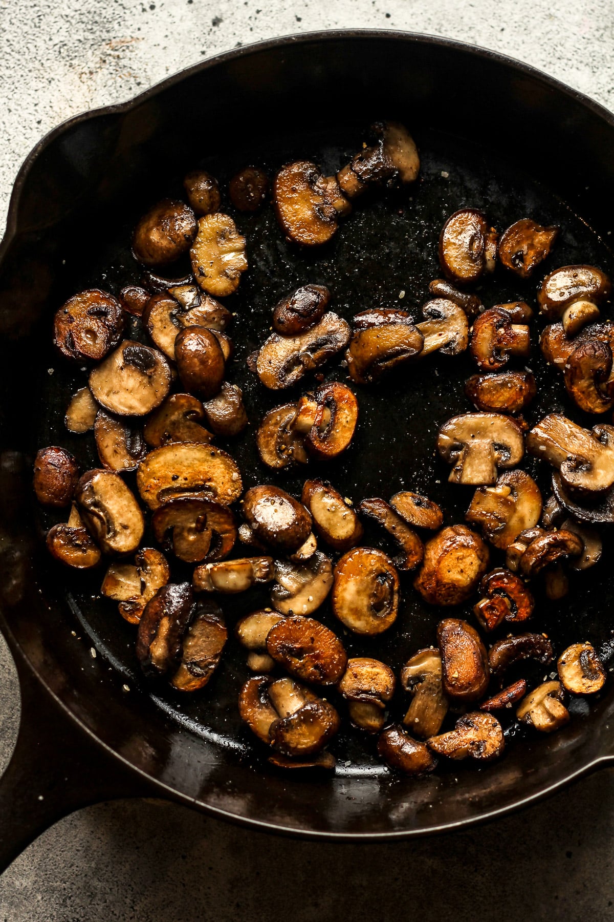 A skillet of browned sliced mushrooms.