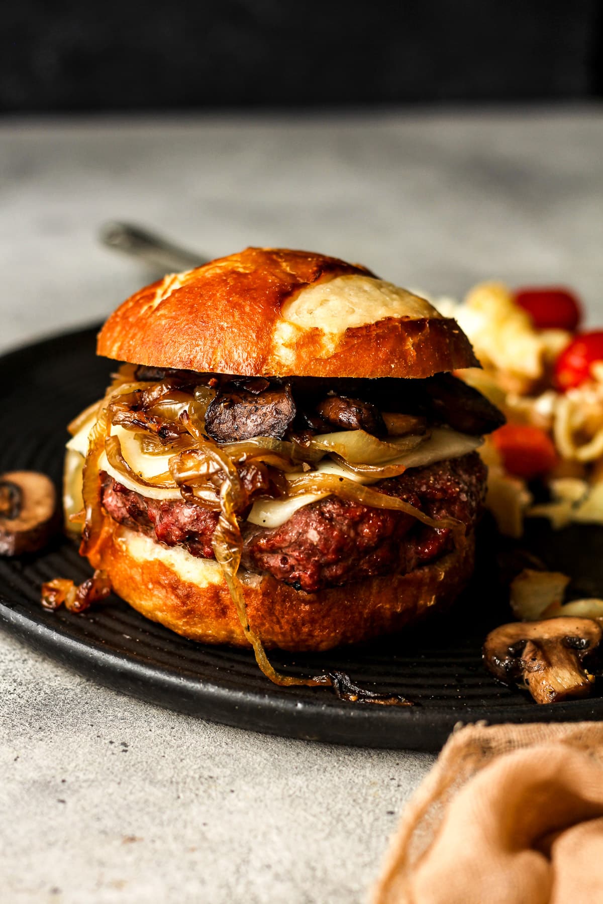 Side view of the burger on a black plate.