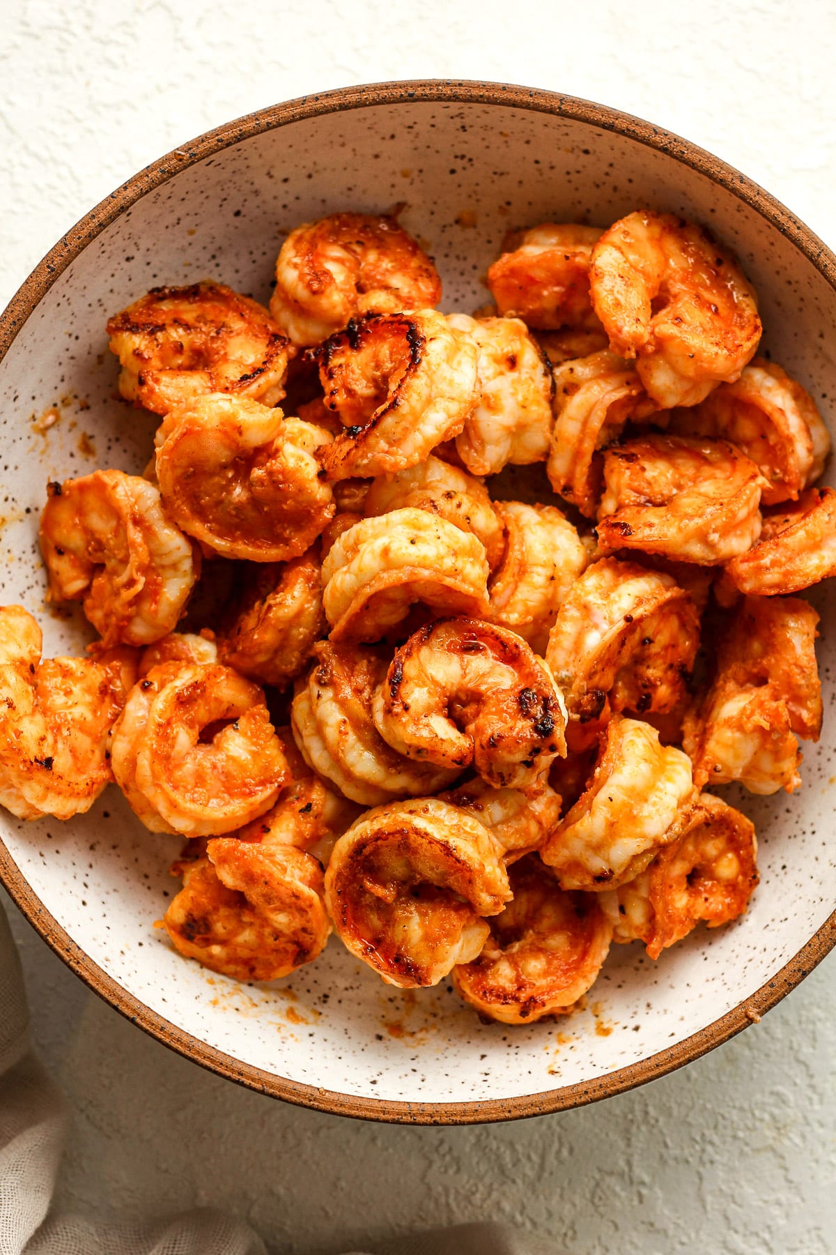A large bowl with the fiery shrimp after cooking in a skillet.