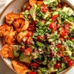 Closeup on a bowl of the cooked shrimp plus the veggie topping.