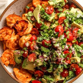 Closeup on a bowl of the cooked shrimp plus the veggie topping.