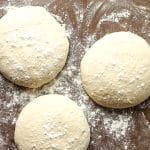 Closeup view of three rounds of sourdough pizza dough.