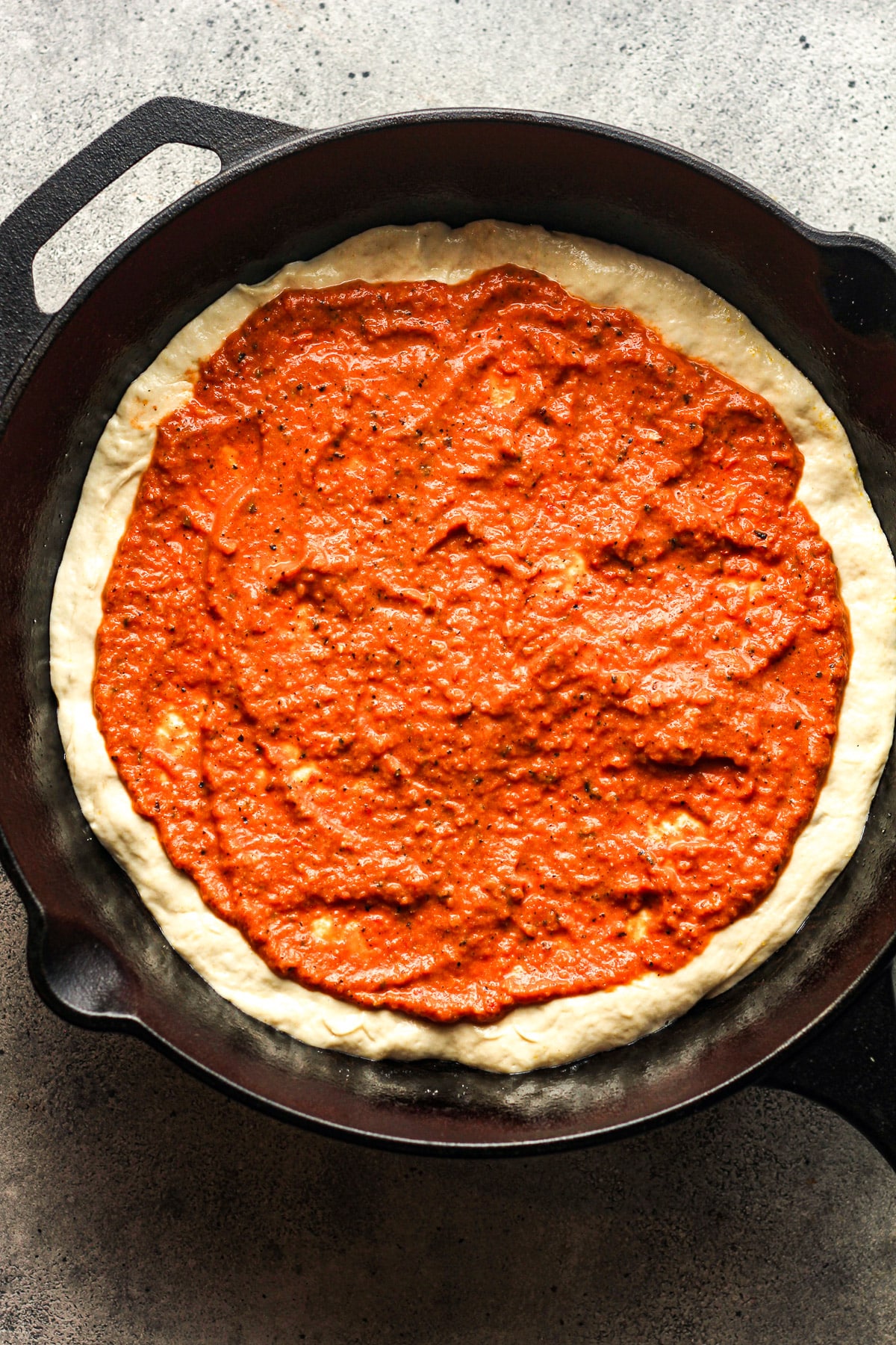 A skillet with the sourdough topped with vodka sauce.