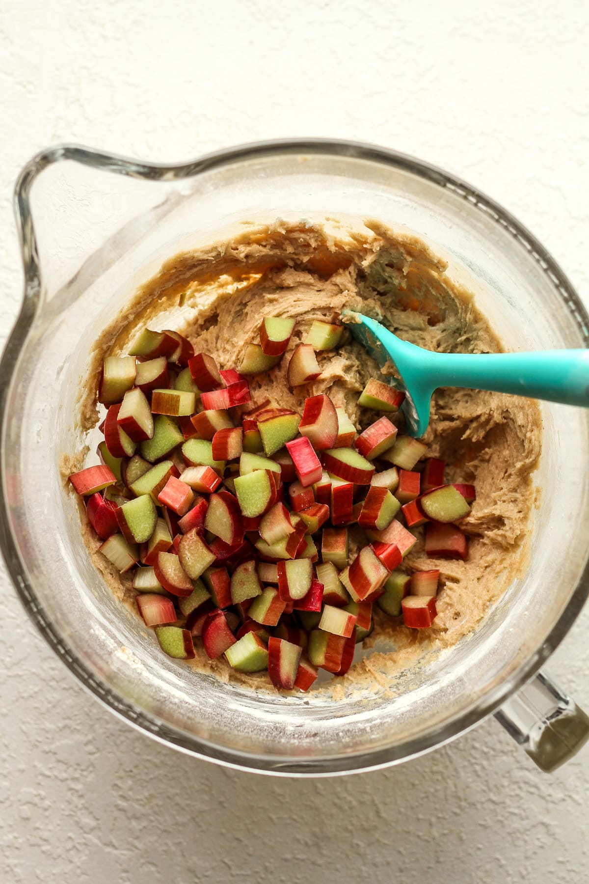A mixing bowl of the cake batter with the chopped rhubarb on top.