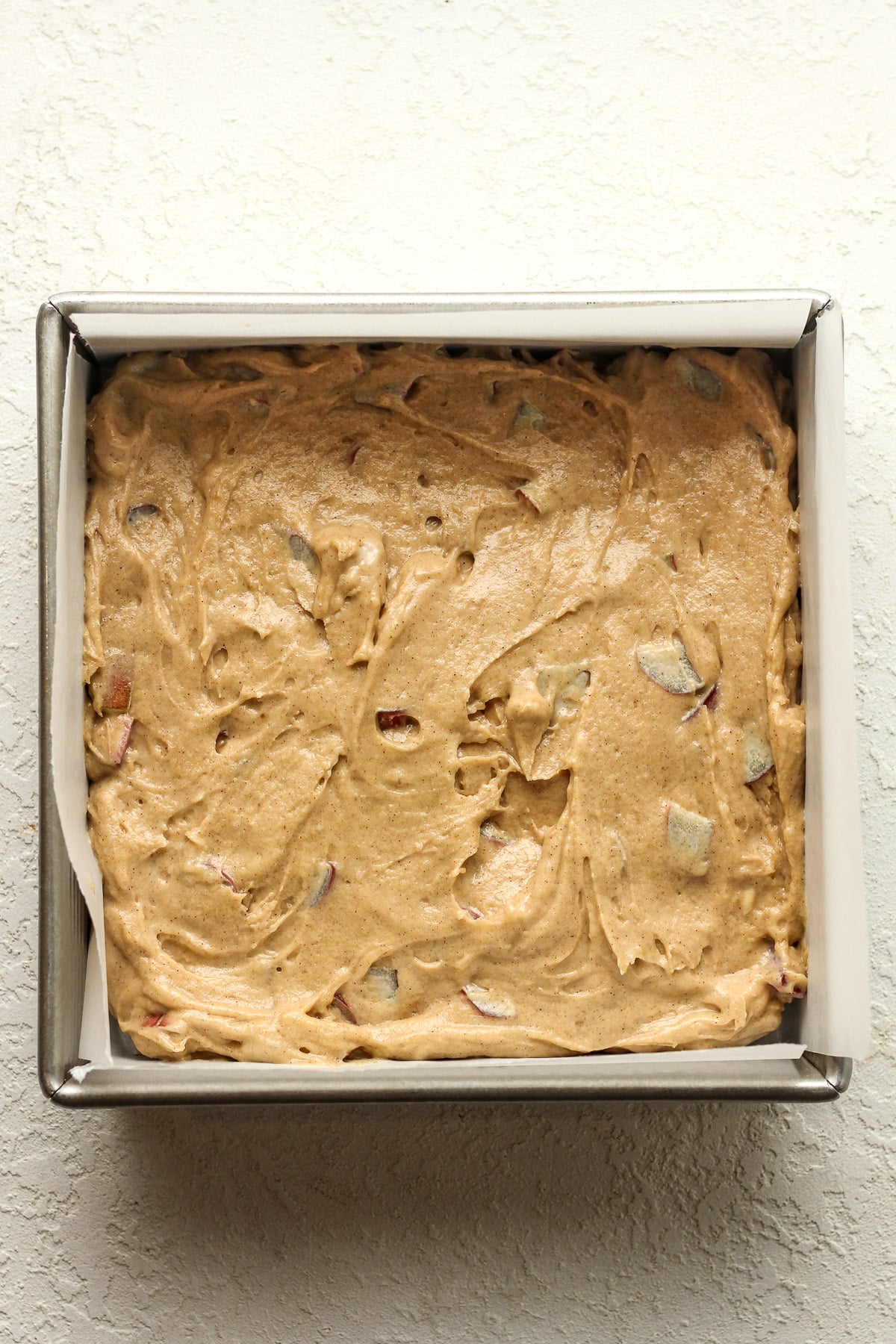 A square pan of the rhubarb cake batter.