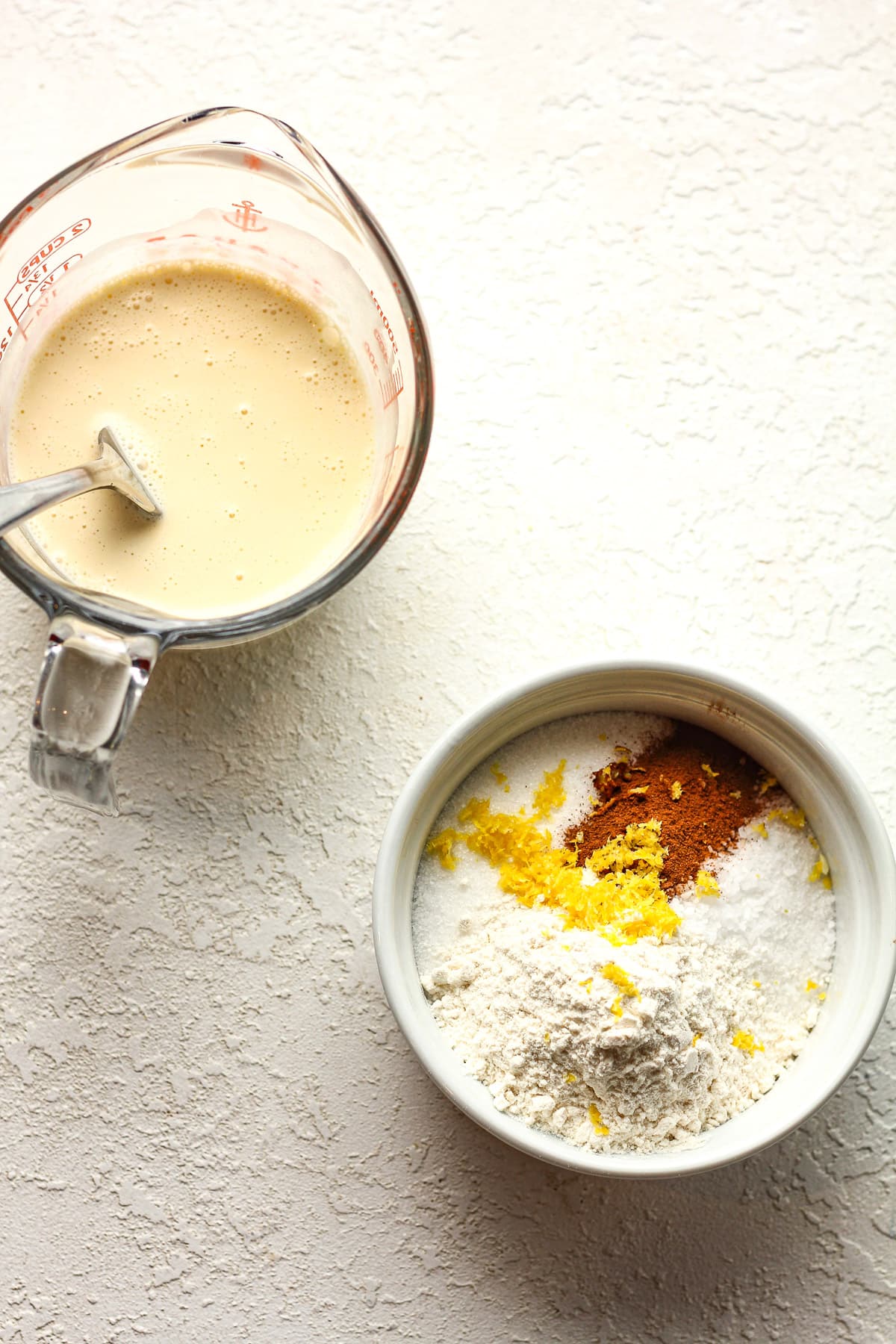 A measuring cup of the wet ingredients and a bowl of the dry ingredients.