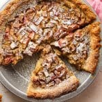 Closeup on a rhubarb custard pie with some of them cut in slices.
