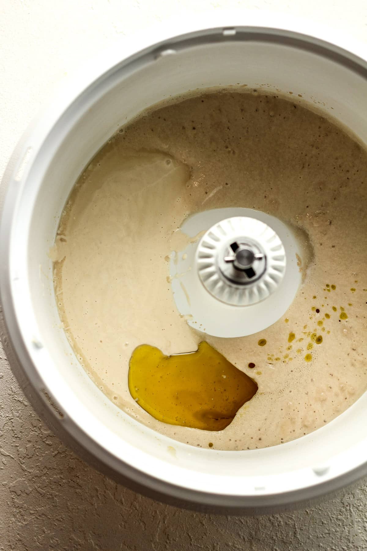 A mixing bowl with the wet ingredients for the sourdough discard pizza dough.