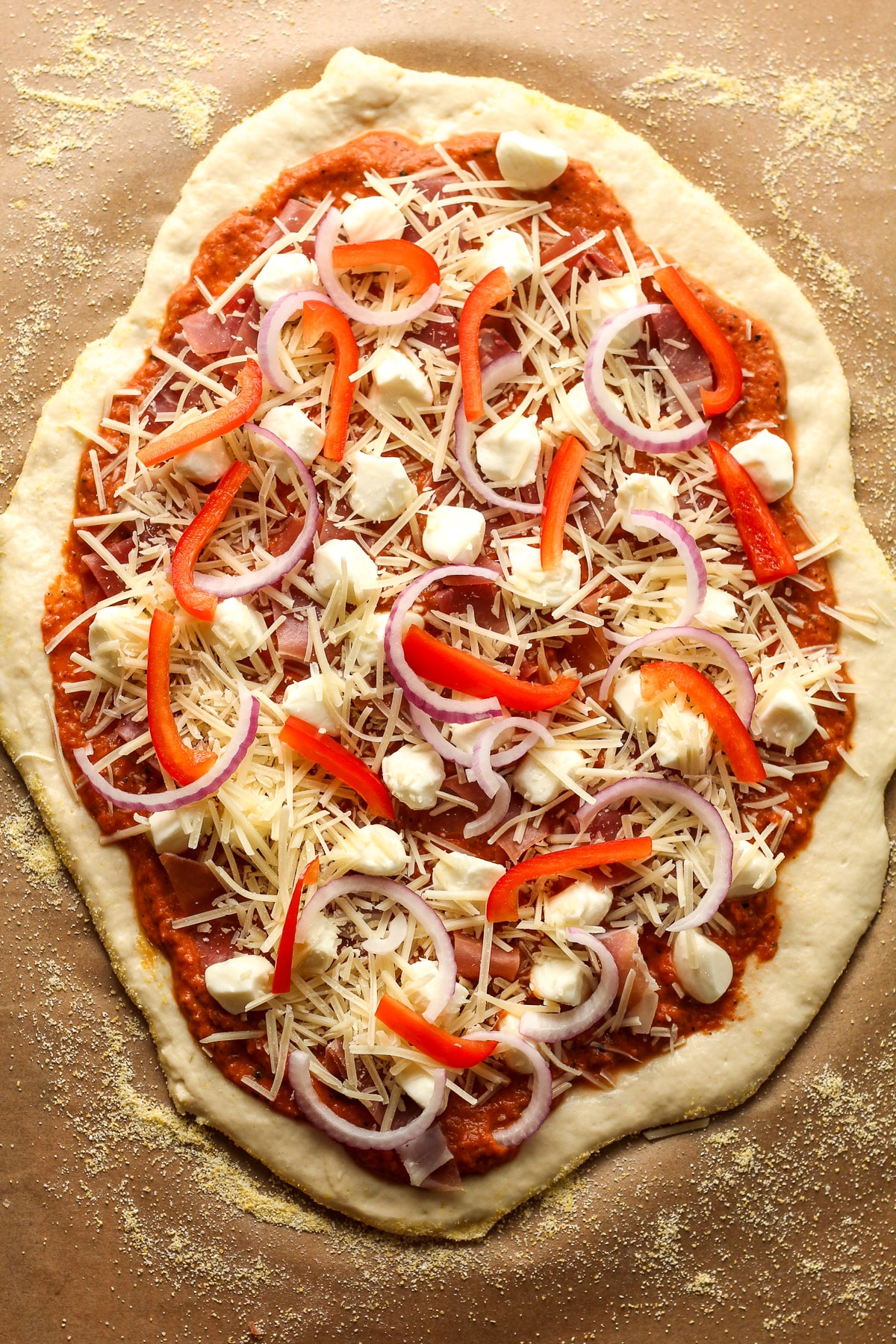 The rolled out dough with vodka pizza sauce and toppings.