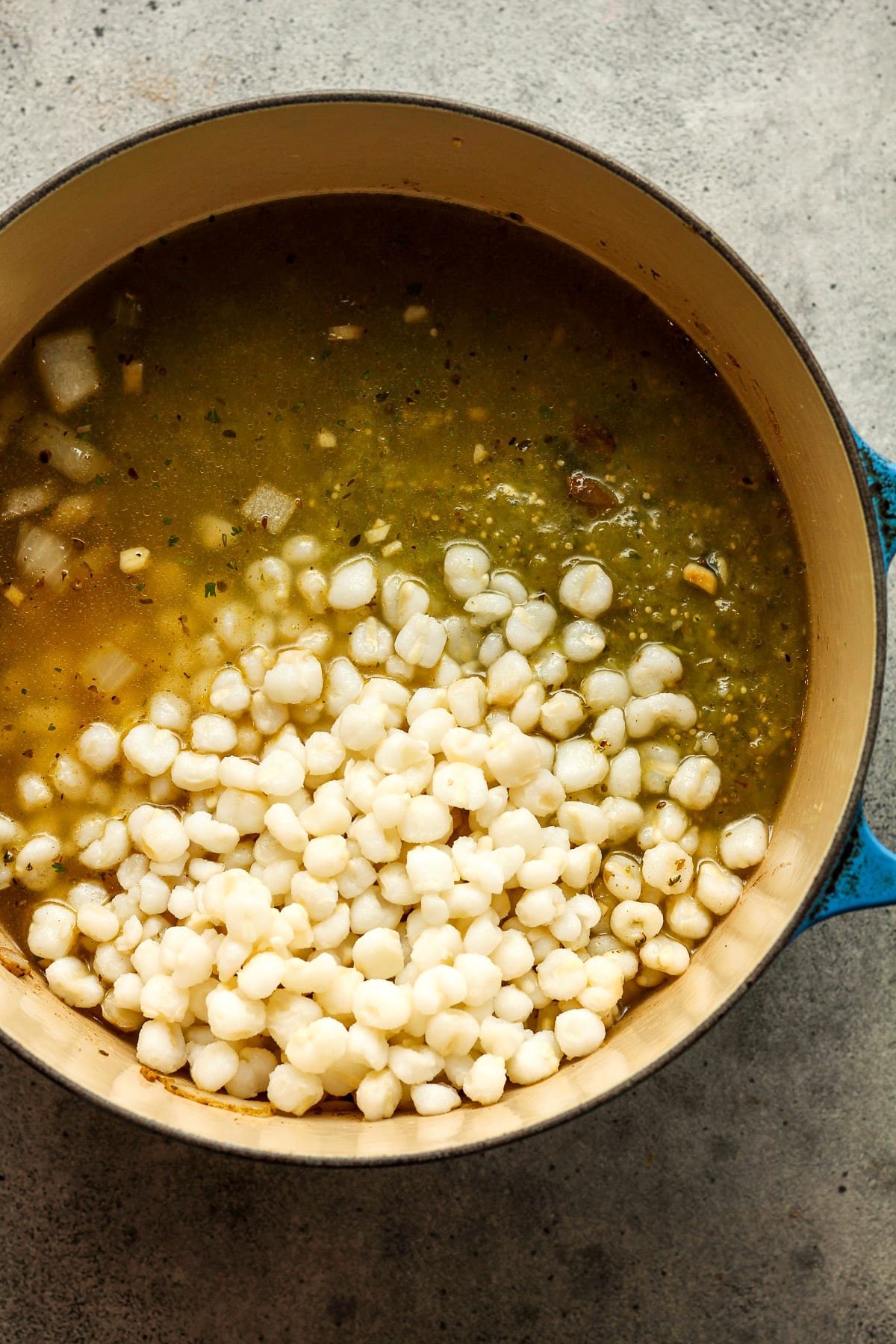 A pot of the soup base after adding hominy.