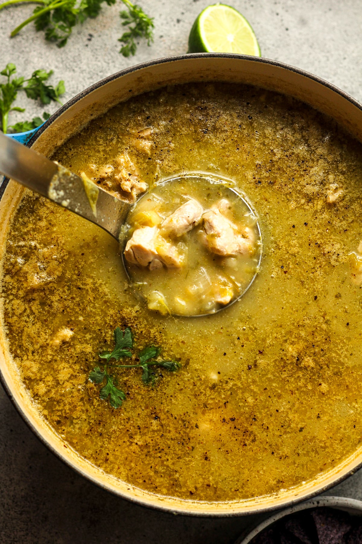 A pot of pozole verde with chicken thighs.