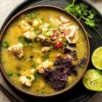 A black bowl of chicken pozole verde.
