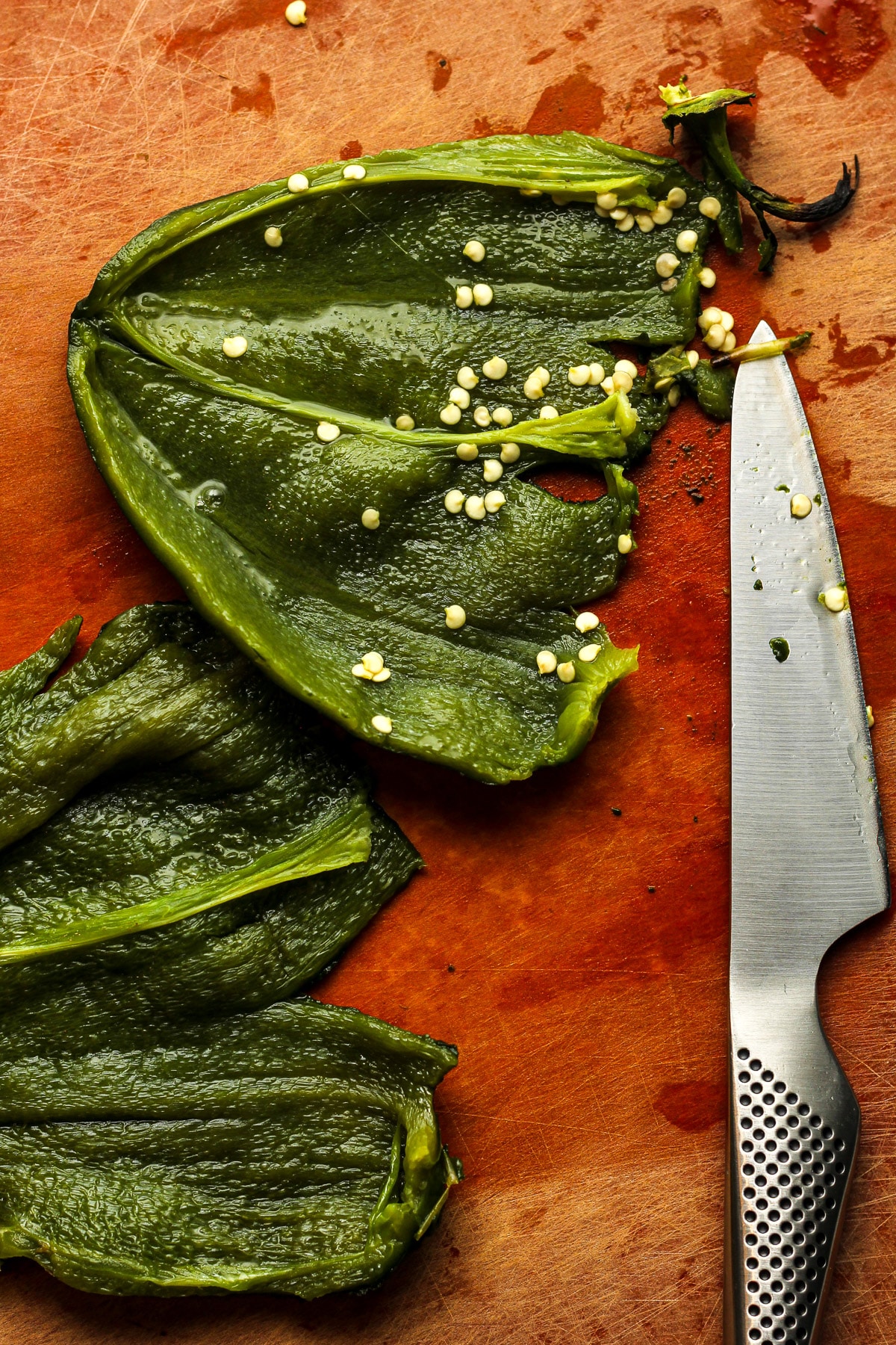 A board showing the opened roasted poblano peppers.
