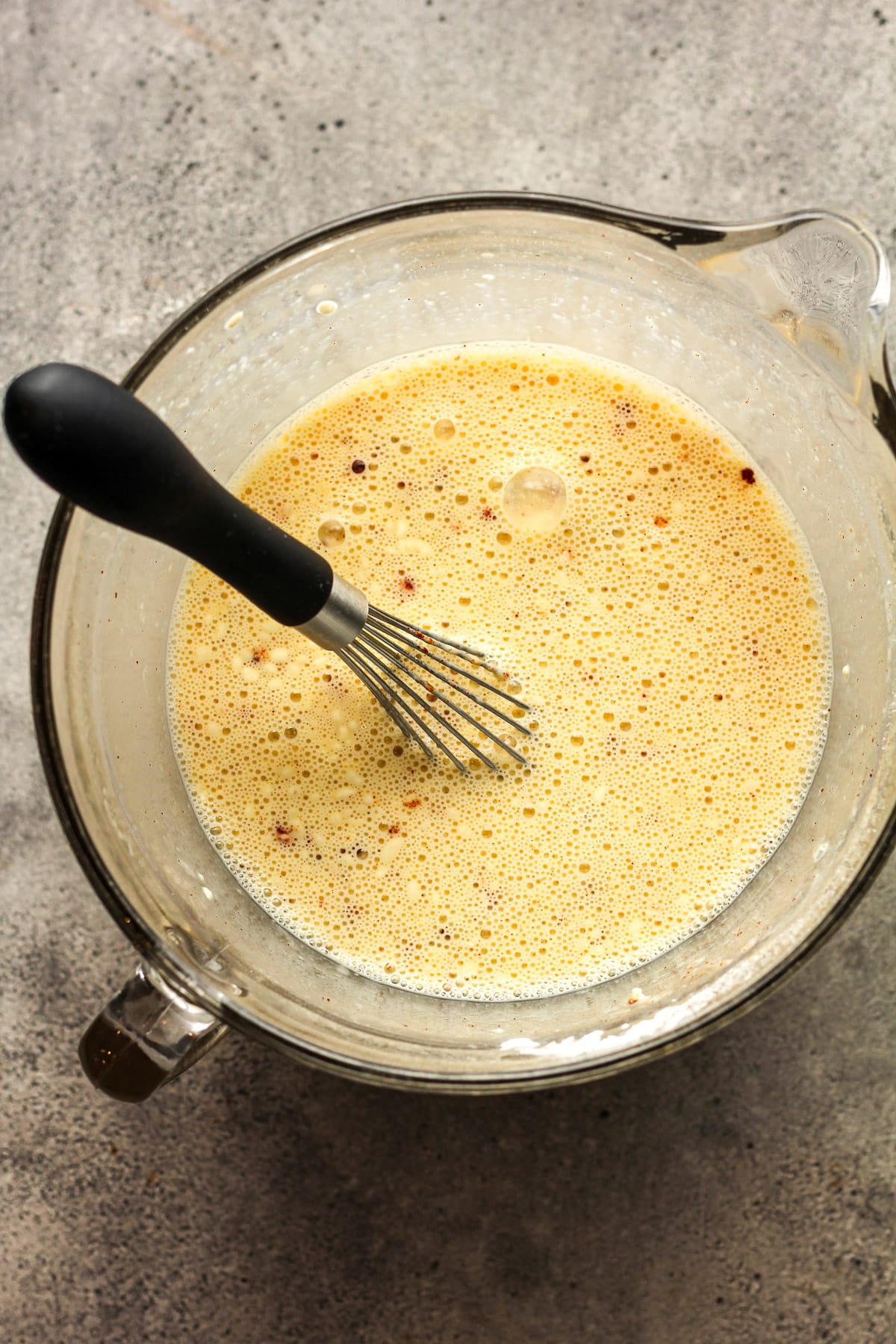 A large measuring cup of the egg mixture.