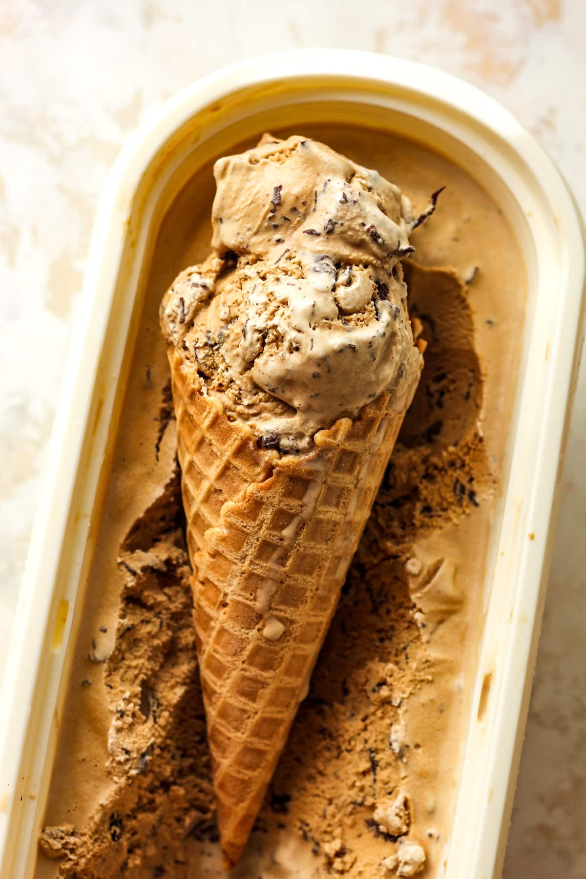 Overhead view of a waffle cone of espresso stracciatella ice cream.